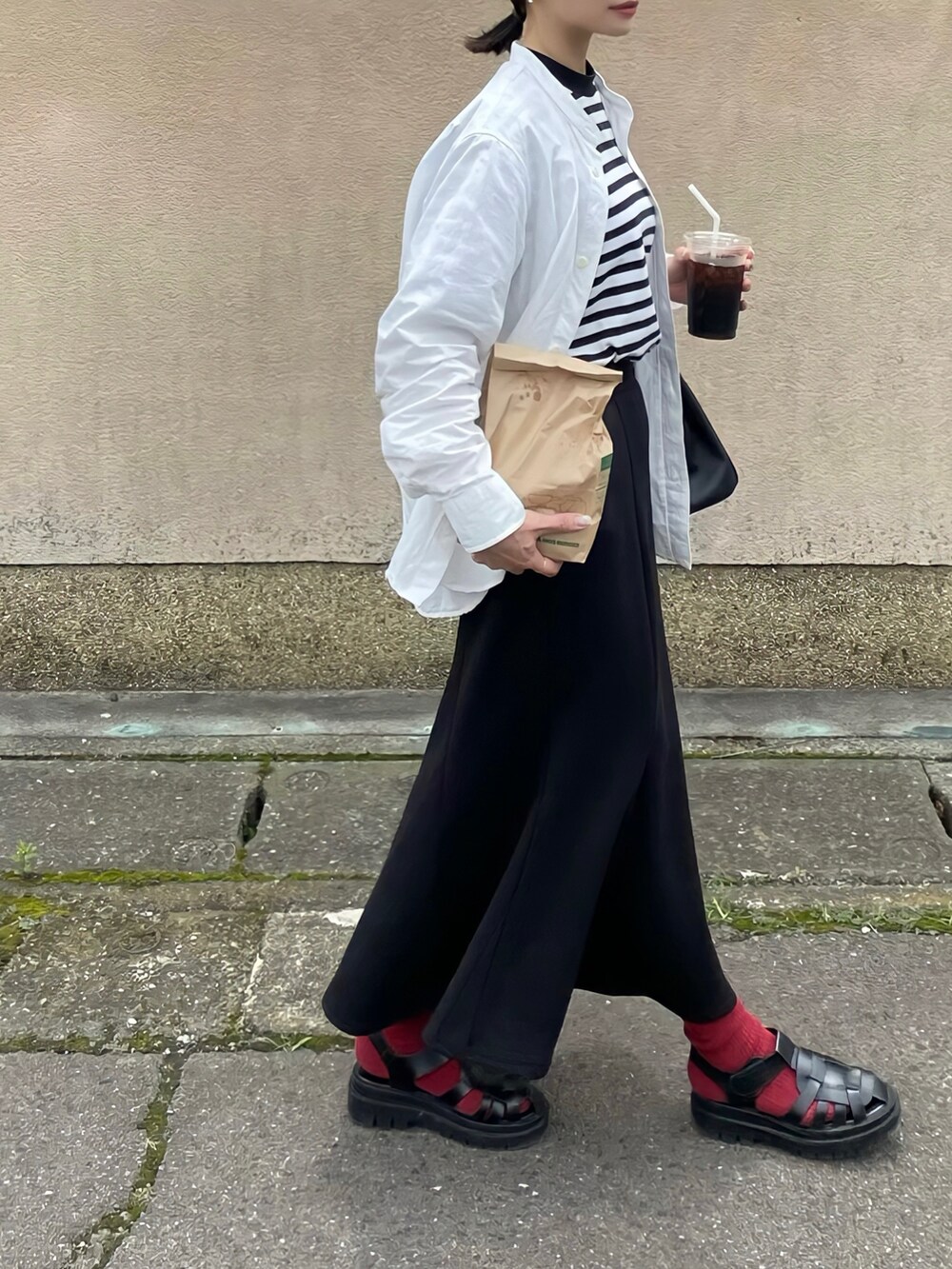 ブラック系のスカート、ブラック系のサンダル、ブラック系のショルダーバッグを着用したレディースの夏コーディネートの2枚目の写真