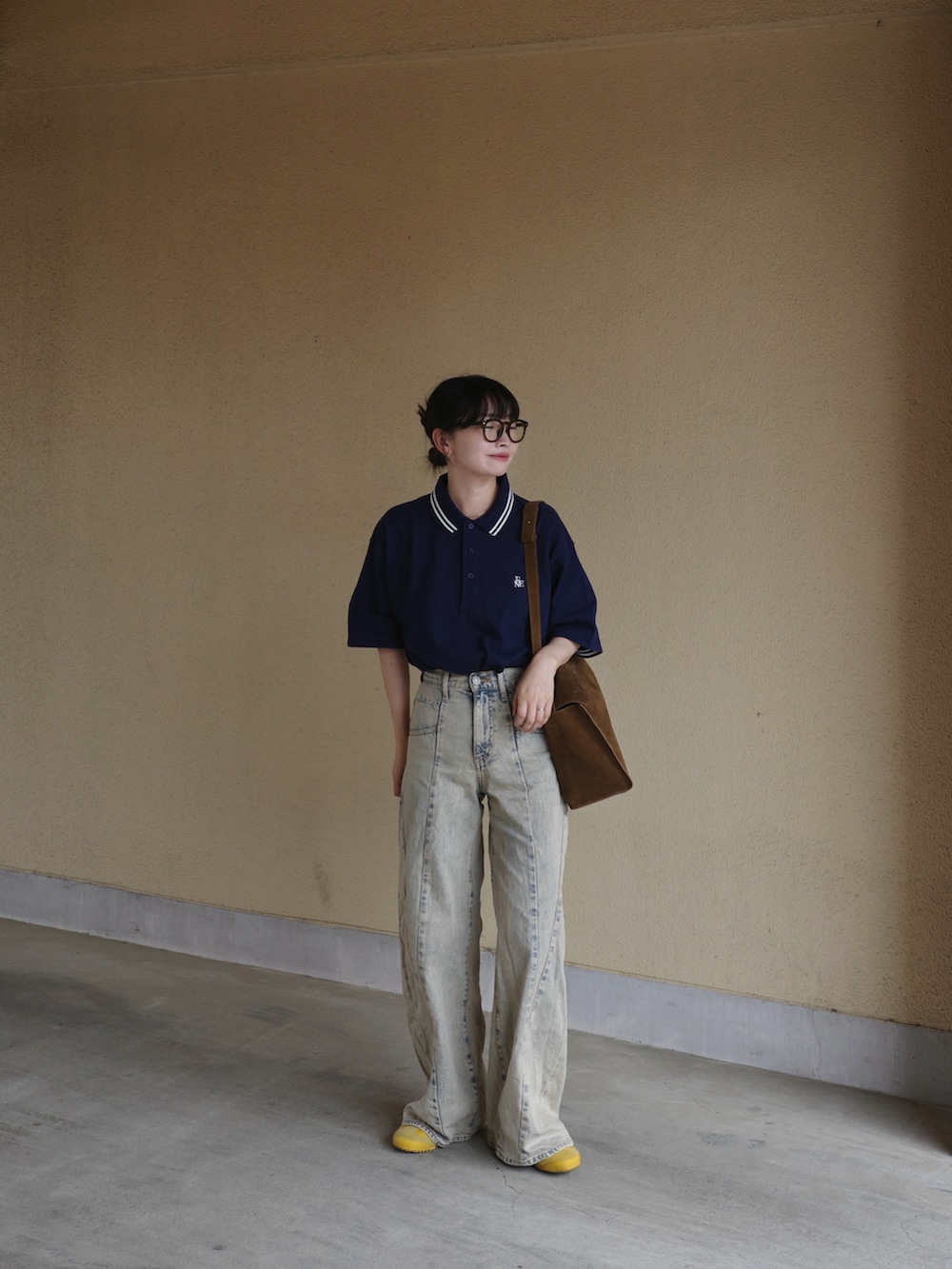 ブルー系のポロシャツ、ブルー系のデニムパンツ、イエロー系のショルダーバッグを着用したレディースの春コーディネートの4枚目の写真