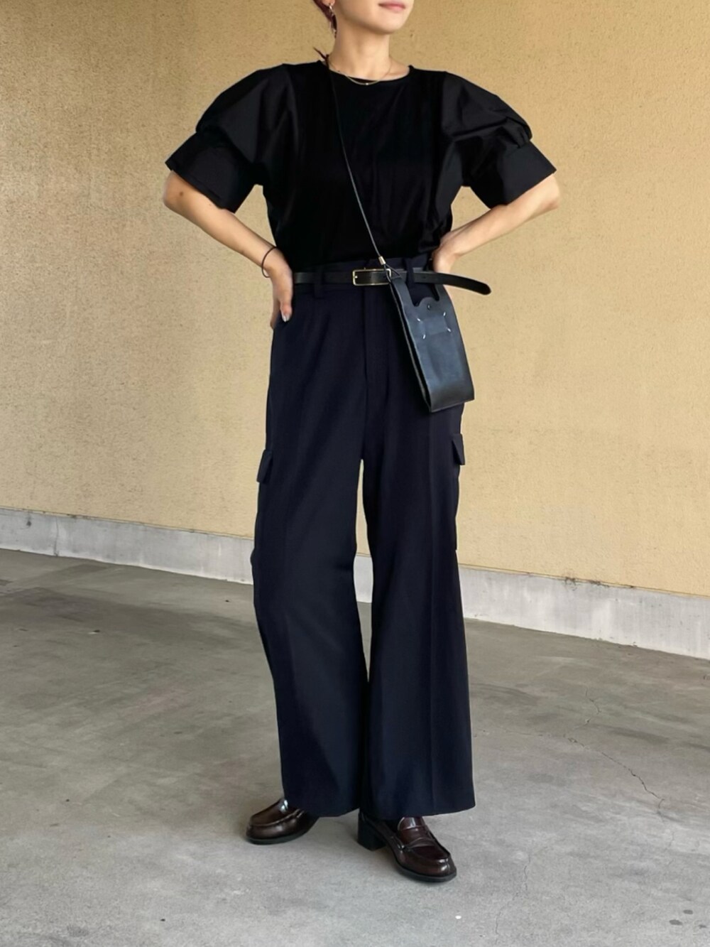 ブラック系のTシャツ/カットソー、ブルー系のカーゴパンツ、ブラウン系のローファーを着用したレディースの秋コーディネートの3枚目の写真