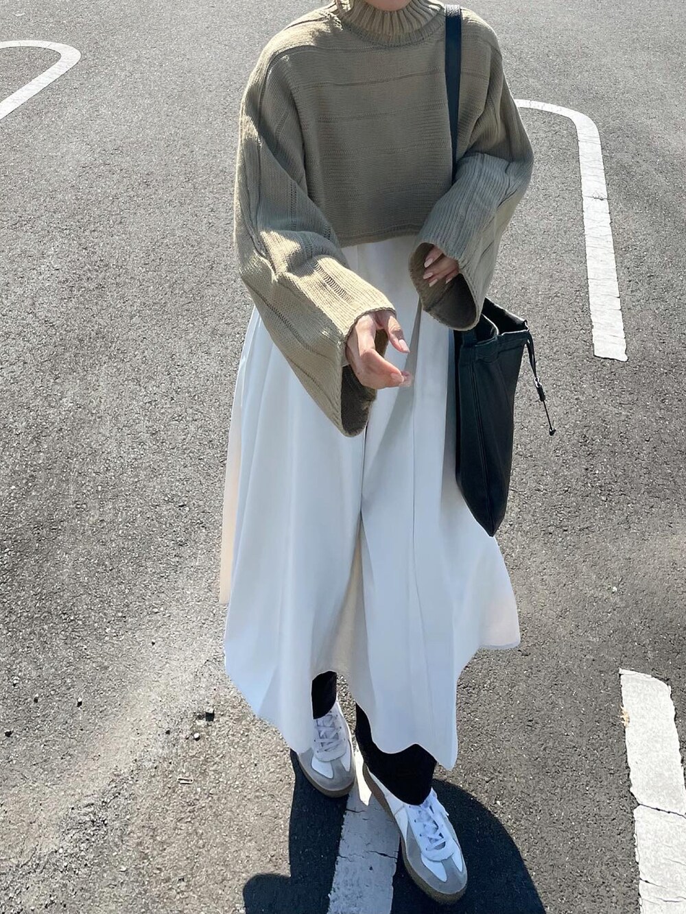 グリーン系のワンピース、ブラック系のショルダーバッグを着用したレディースの秋コーディネートの5枚目の写真