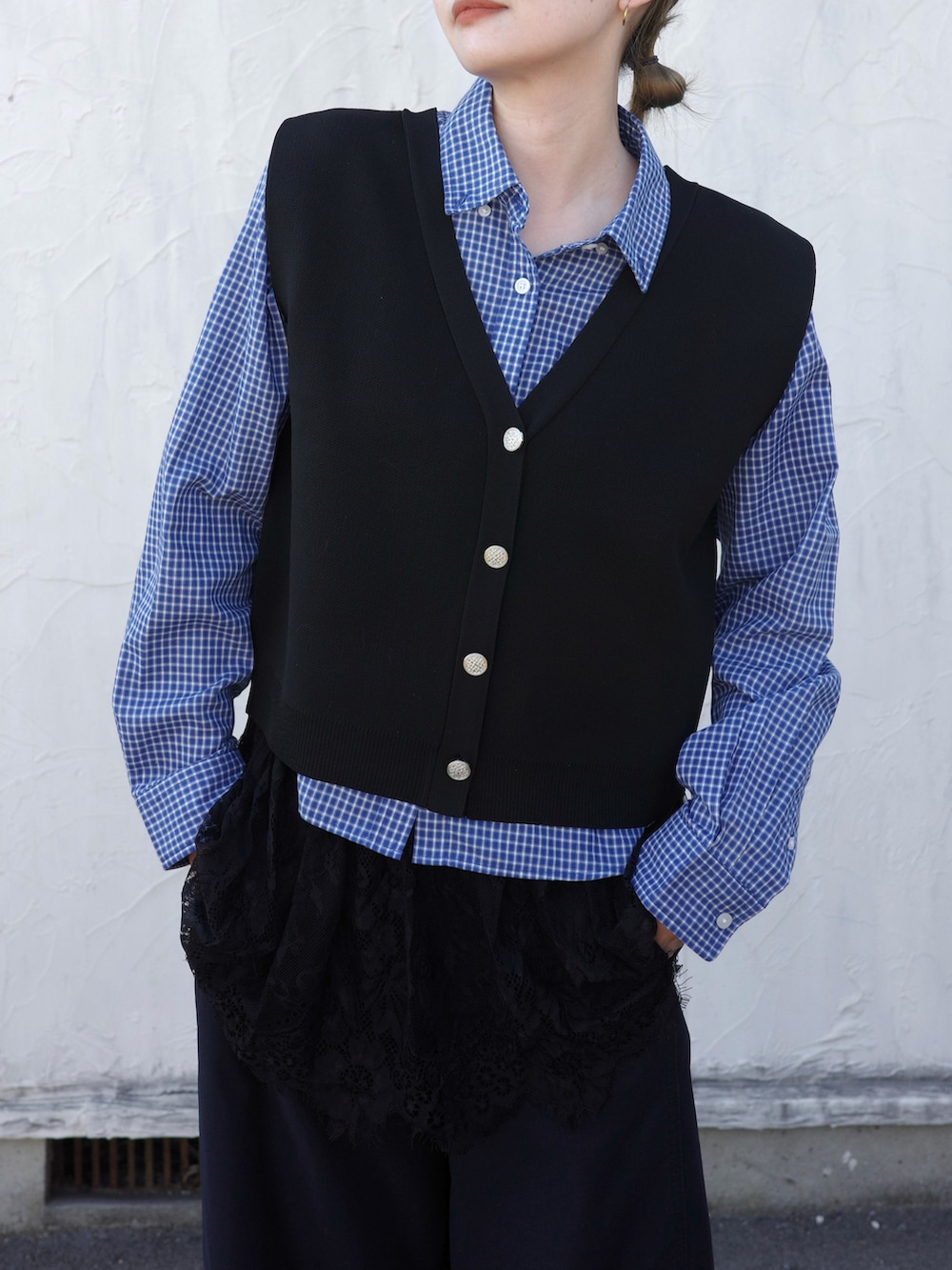 ブラック系のベストを着用したレディースの春コーディネートの2枚目の写真