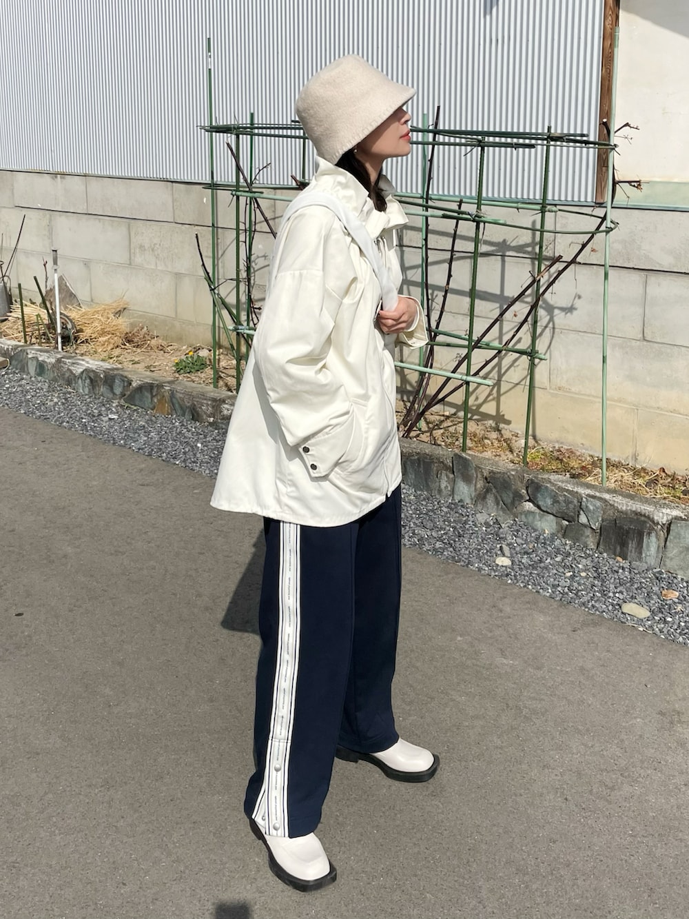 ホワイト系のブルゾン、ブルー系のパンツ、ベージュ系のハットを着用したレディースの春コーディネートの2枚目の写真