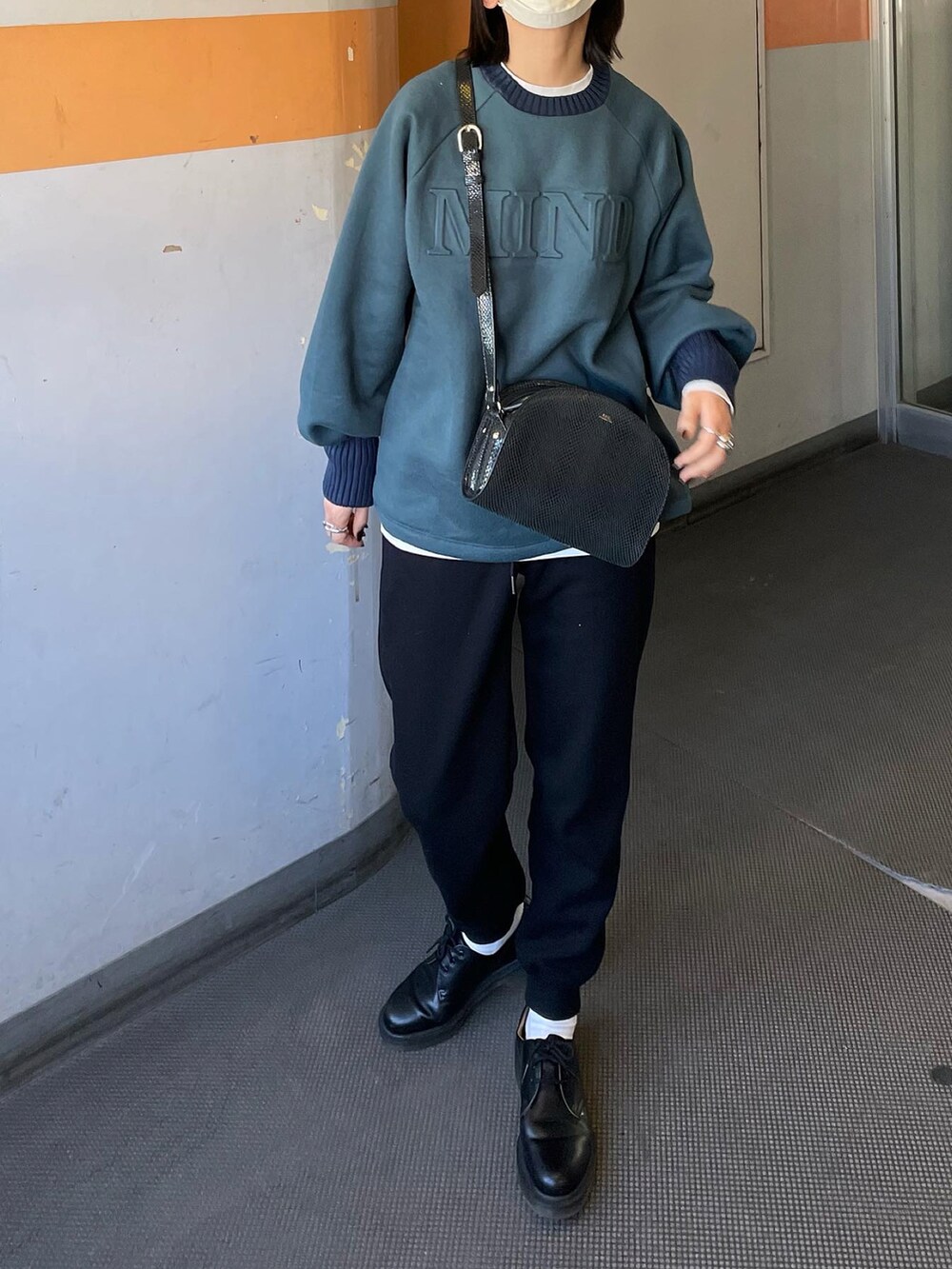 グリーン系のスウェット、ブラック系のスウェットパンツ、シルバー系のリングを着用したレディースの冬コーディネートの3枚目の写真