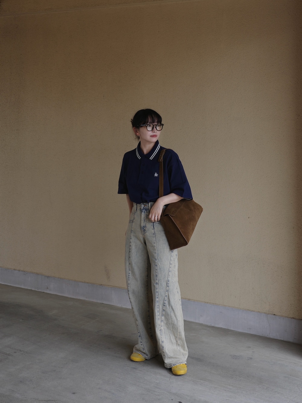 ブルー系のポロシャツ、ブルー系のデニムパンツ、イエロー系のショルダーバッグを着用したレディースの春コーディネートの2枚目の写真