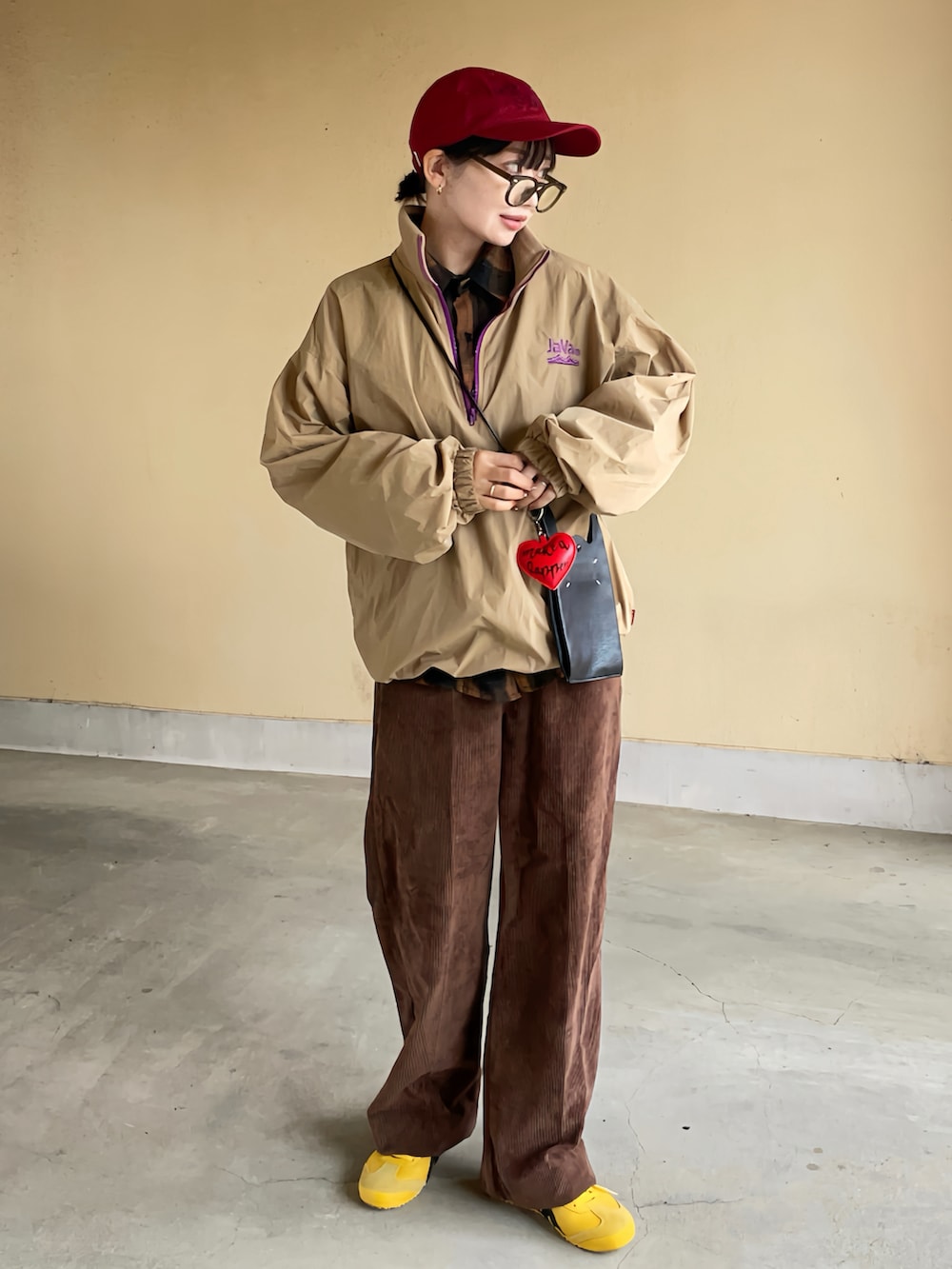 ベージュ系のブルゾン、イエロー系のスニーカーを着用したレディースの秋コーディネートの2枚目の写真