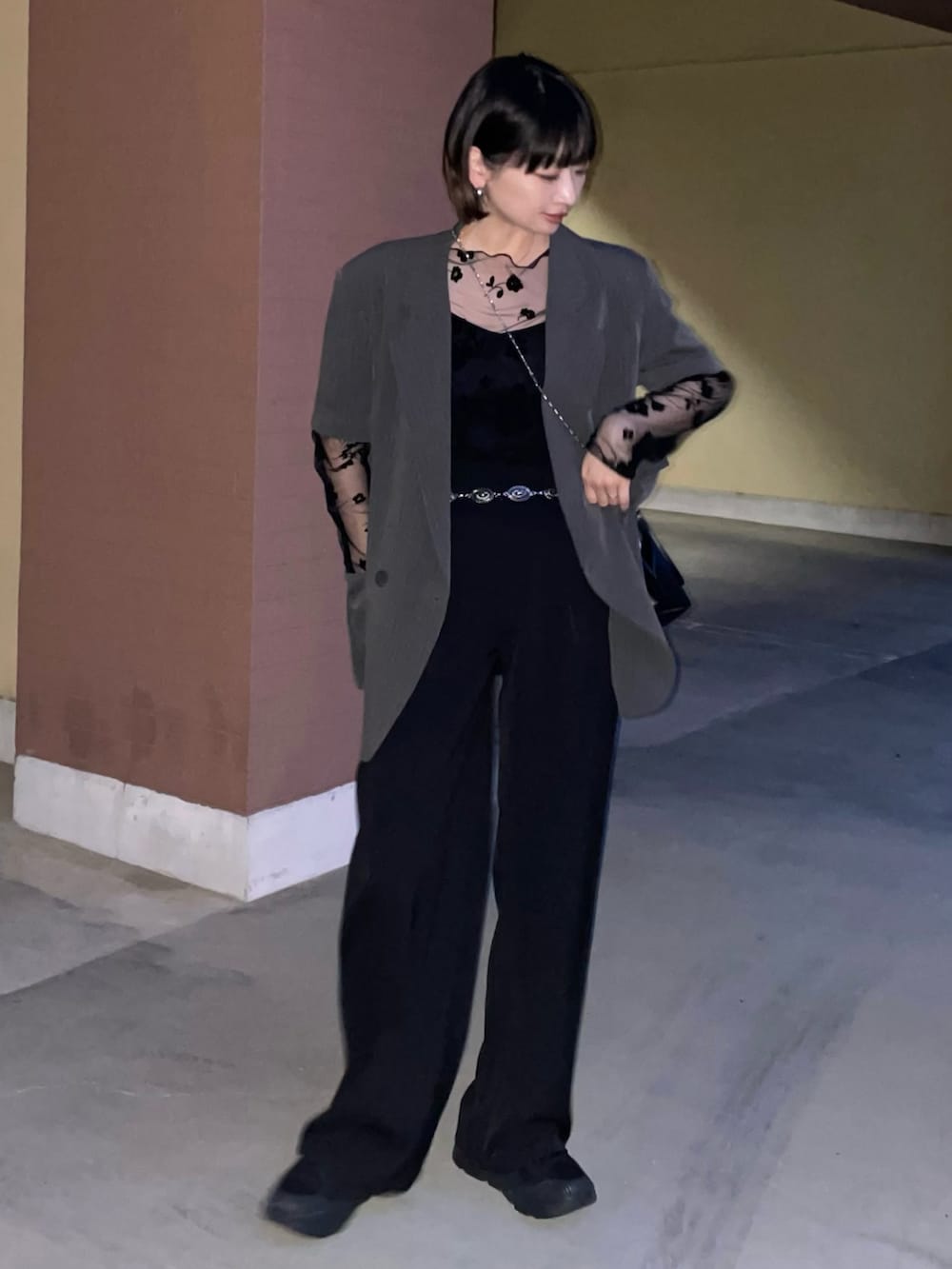 グレー系のテーラードジャケット、ブラック系のショルダーバッグ、ブラック系のスニーカーを着用したレディースの夏コーディネートの2枚目の写真