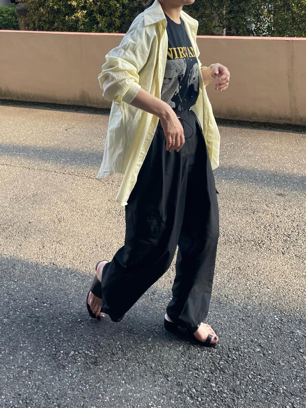 ブラック系のその他パンツ、ブラック系のサンダル、イエロー系のシャツ/ブラウスを着用したレディースの春コーディネートの3枚目の写真