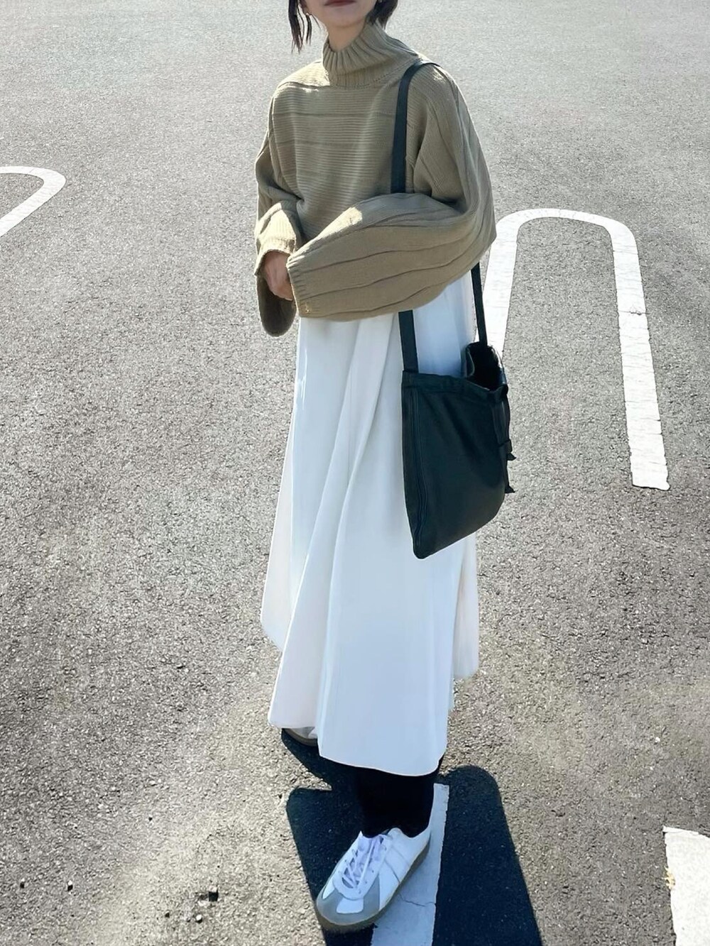 グリーン系のワンピース、ブラック系のショルダーバッグを着用したレディースの秋コーディネートの3枚目の写真