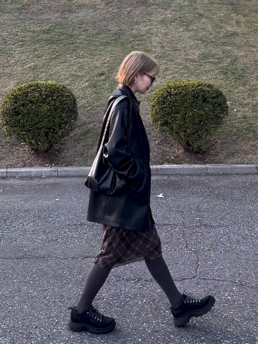 ブラック系のスニーカーを着用したレディースの秋コーディネートの2枚目の写真