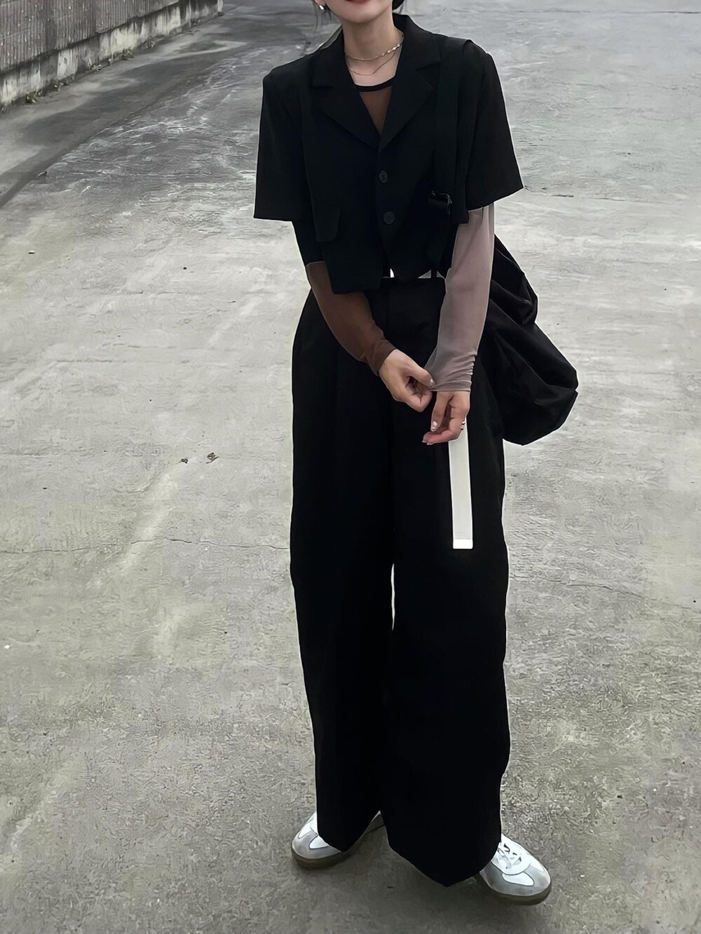 ブラック系のテーラードジャケット、ブラック系のパンツ、ホワイト系のベルトを着用したレディースの夏コーディネートの2枚目の写真