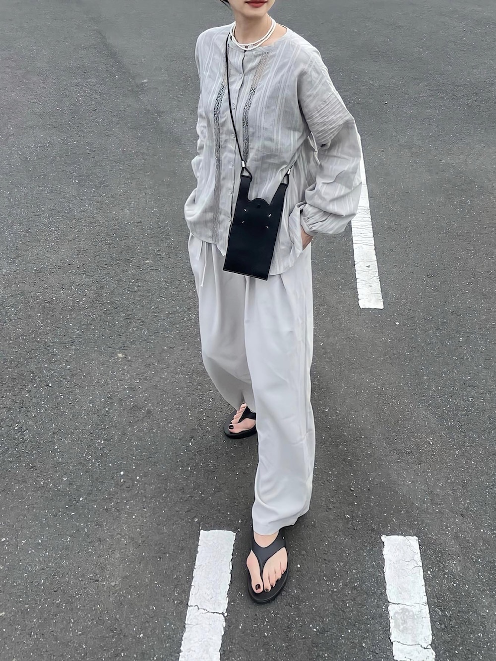 グリーン系のシャツ/ブラウス、ブラック系のサンダル、ホワイト系のパンツを着用したレディースの夏コーディネートの2枚目の写真