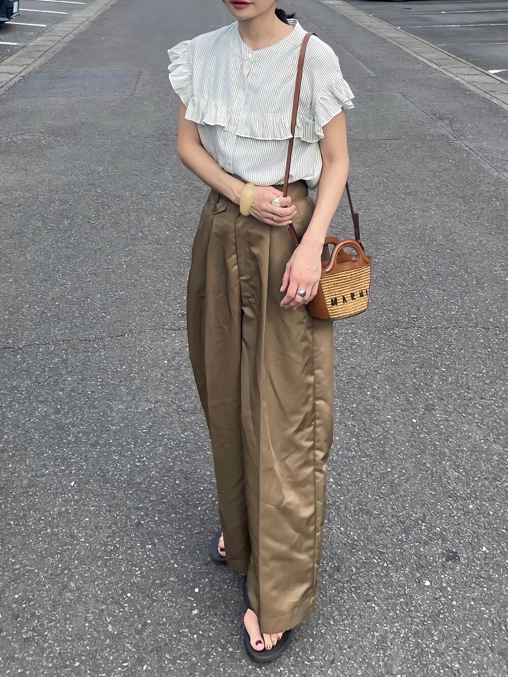 グリーン系のシャツ/ブラウスを着用したレディースの夏コーディネートの2枚目の写真