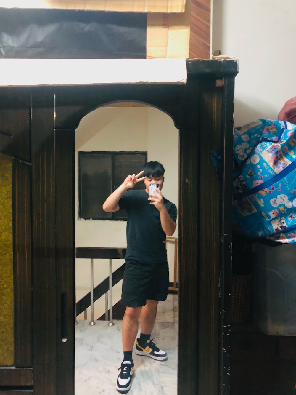 ブラック系のスニーカー、ホワイト系のTシャツ/カットソー、ブラック系のカーゴパンツを着用したメンズの冬コーディネートの2枚目の写真