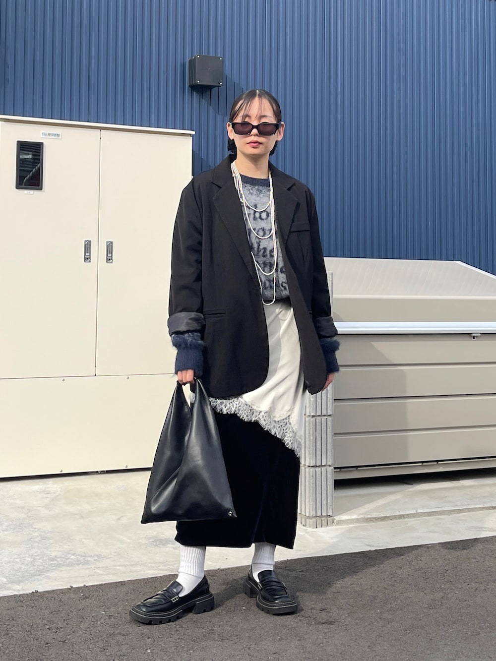 ブルー系のニット/セーター、ブラック系のローファー、ブラック系のトートバッグを着用したレディースの秋コーディネートの2枚目の写真