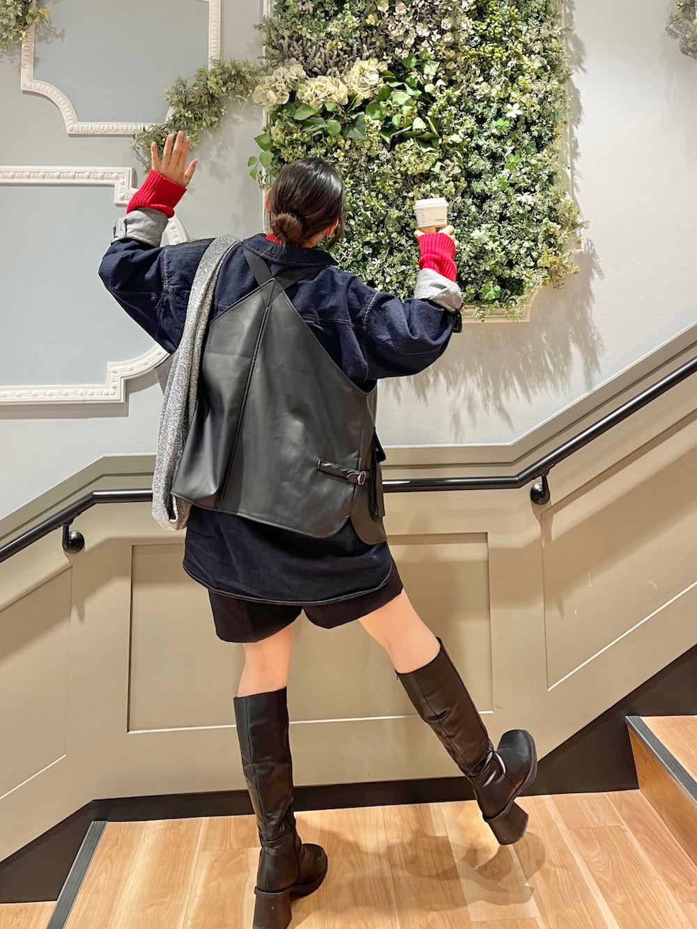 ブラック系のブーツ、シルバー系のトートバッグ、ブラック系のパンツを着用したレディースの冬コーディネートの2枚目の写真