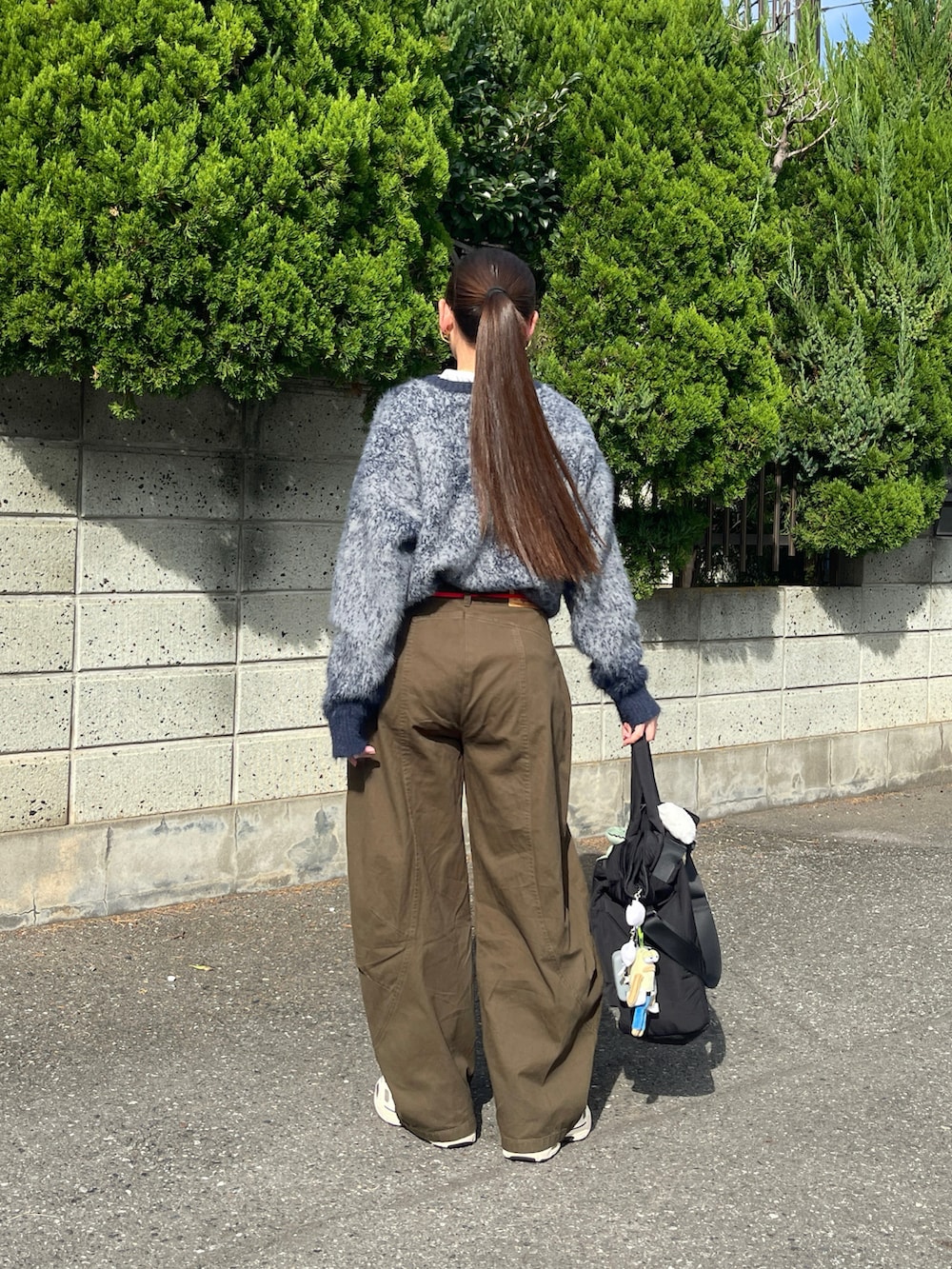 ブルー系のニット/セーター、グリーン系のデニムパンツ、ベージュ系のスニーカーを着用したレディースの秋コーディネートの2枚目の写真