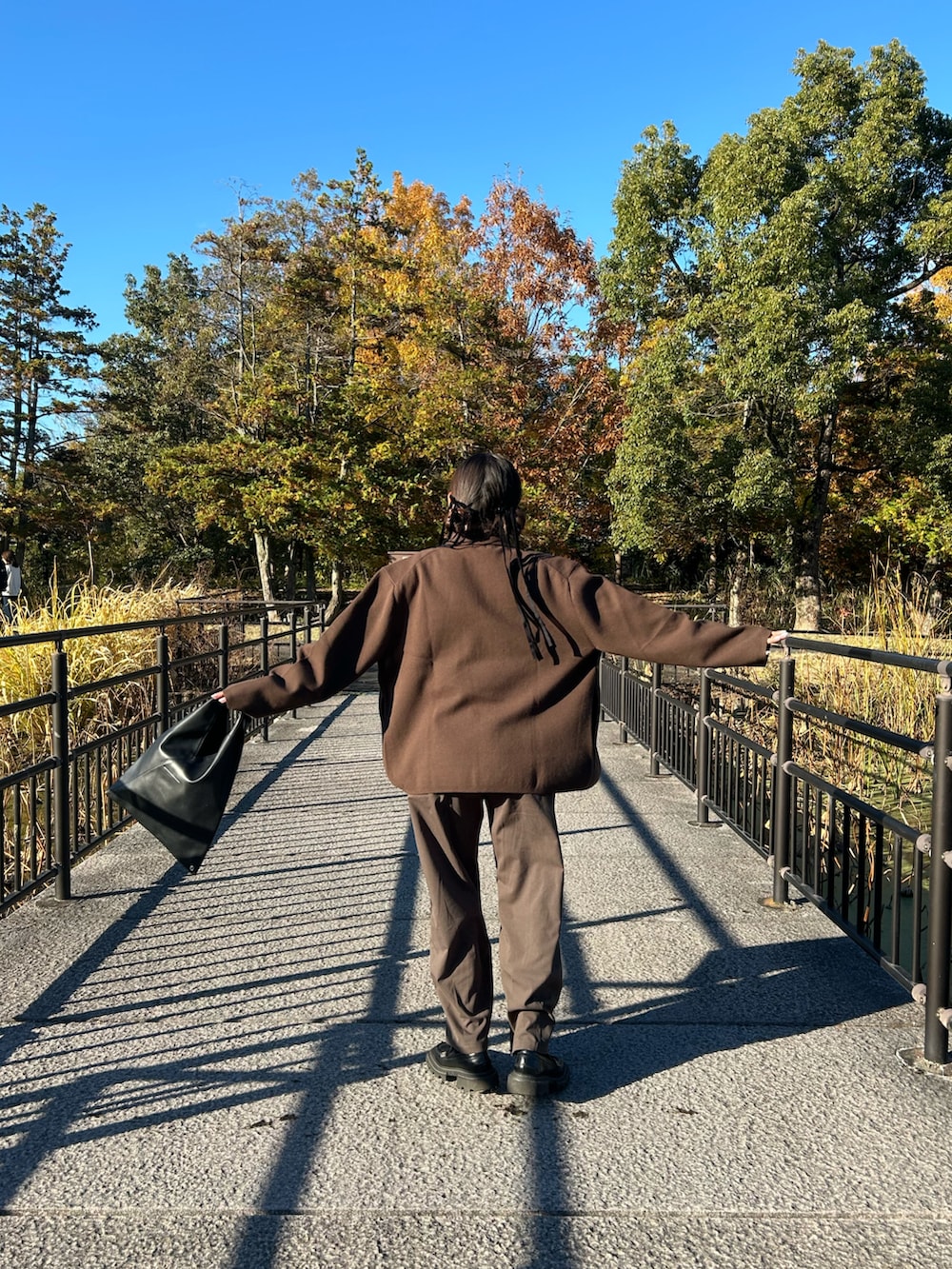 ブラウン系のカーディガン/ボレロ、ブラウン系のスラックス、ブラック系のローファーを着用したレディースの冬コーディネートの2枚目の写真