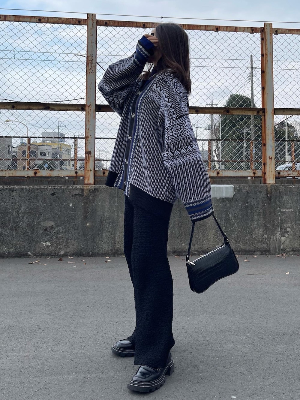 グレー系のカーディガン/ボレロ、ブラック系のショルダーバッグ、ブラック系のローファーを着用したレディースの冬コーディネートの5枚目の写真