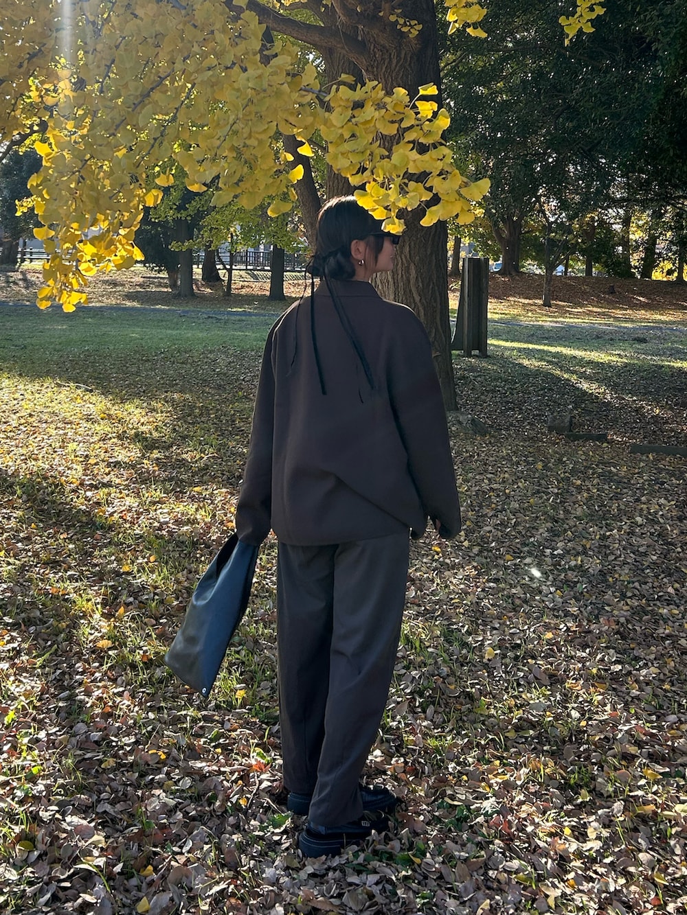 ブラウン系のカーディガン/ボレロ、ブラウン系のスラックス、ブラック系のローファーを着用したレディースの冬コーディネートの4枚目の写真