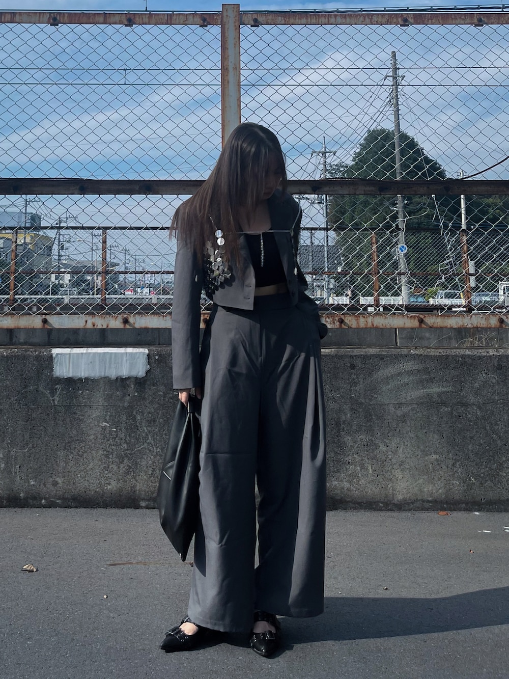 グレー系のセットアップ、ブラック系のハンドバッグ、シルバー系のファッション雑貨を着用したレディースの冬コーディネートの3枚目の写真