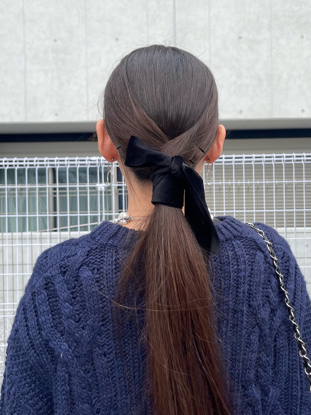 ホワイト系のスカート、ブラック系のバックパック/リュック、ブルー系のニット/セーターを着用したレディースの冬コーディネートの4枚目の写真