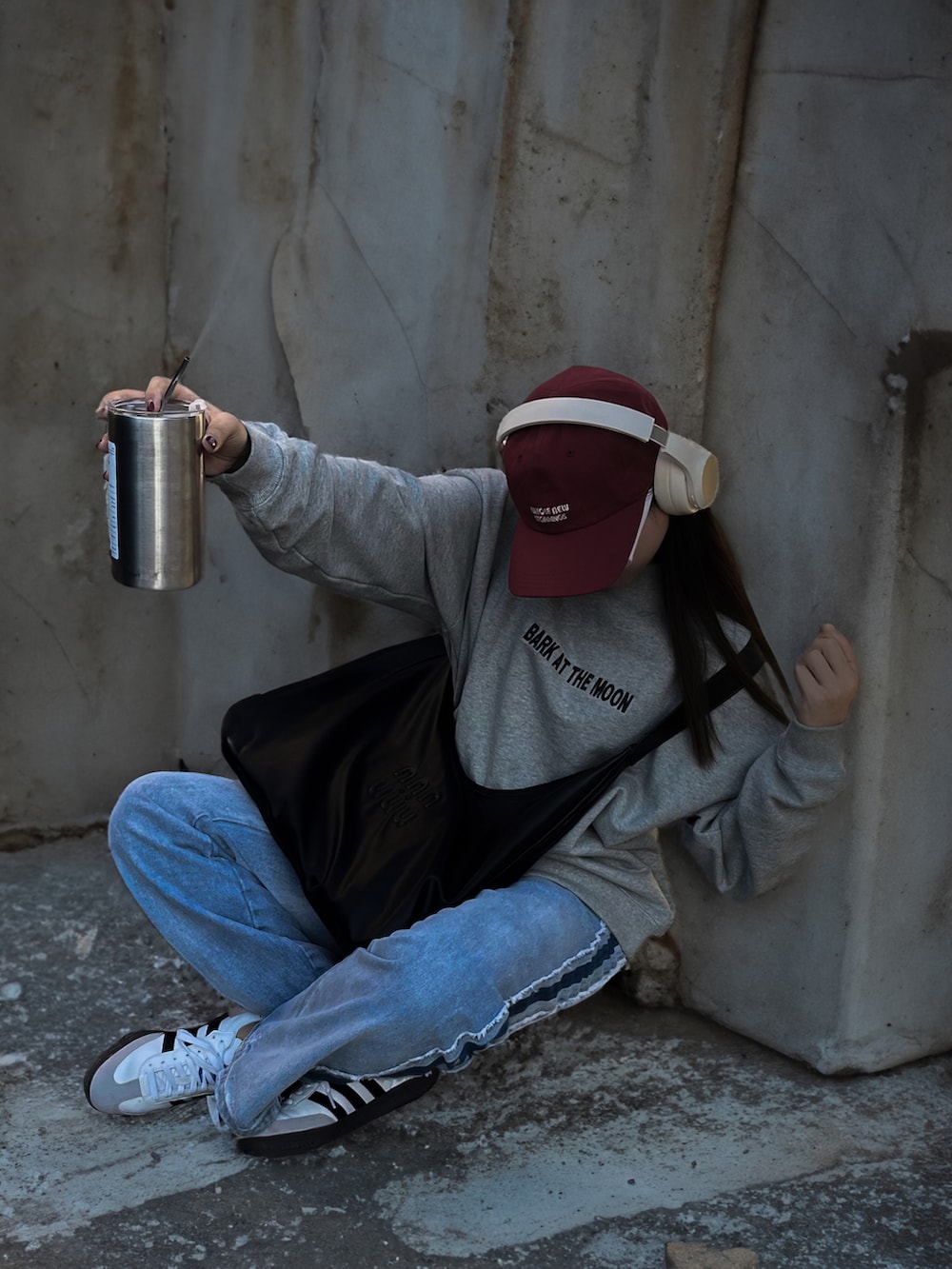 グレー系のスウェット、ブルー系のデニムパンツ、ホワイト系のスニーカーを着用したレディースの冬コーディネートの2枚目の写真