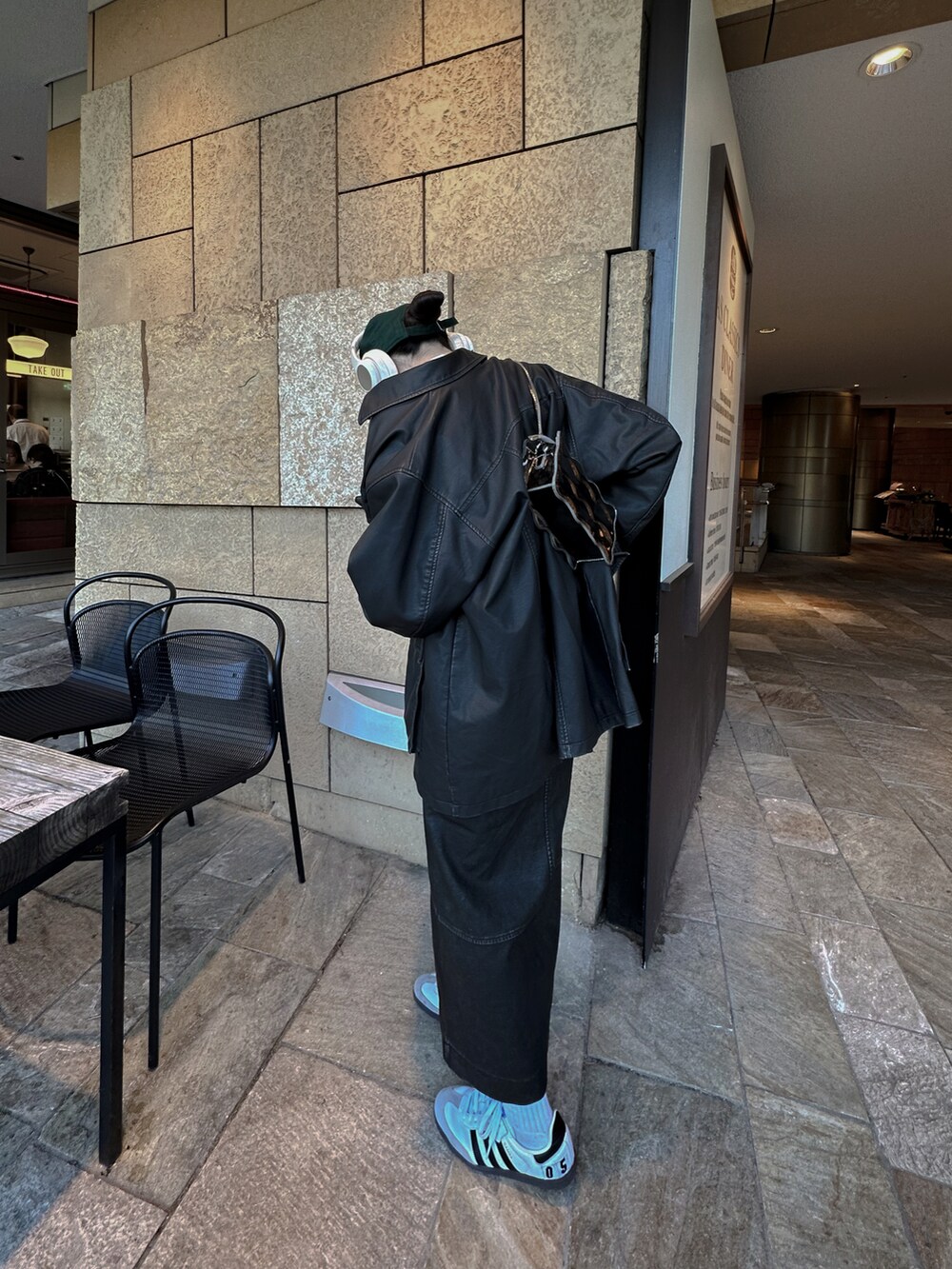 ブラック系のミリタリージャケット、ブラック系のスカート、ホワイト系のスニーカーを着用したレディースの冬コーディネートの2枚目の写真