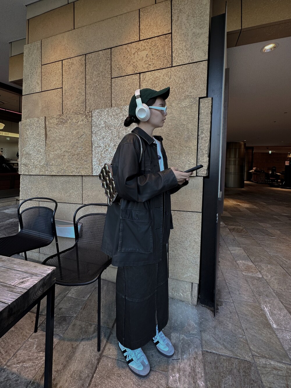 ブラック系のミリタリージャケット、ブラック系のスカート、ホワイト系のスニーカーを着用したレディースの冬コーディネートの3枚目の写真