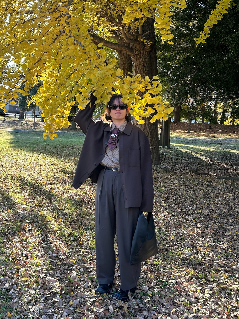 ブラウン系のカーディガン/ボレロ、ブラウン系のスラックス、ブラック系のローファーを着用したレディースの冬コーディネートの3枚目の写真