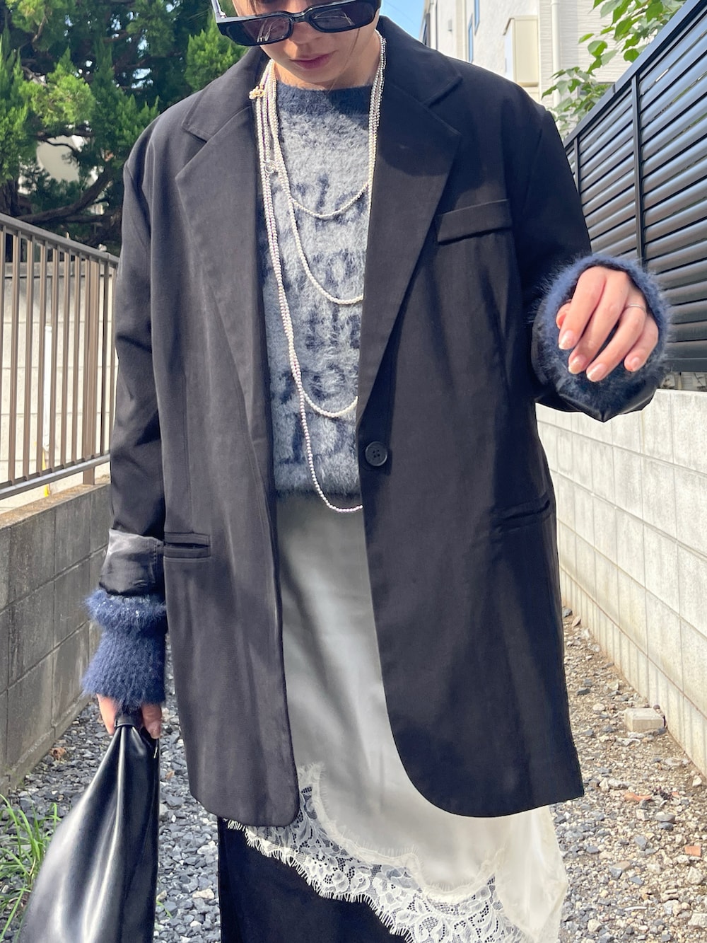 ブルー系のニット/セーター、ブラック系のローファー、ブラック系のトートバッグを着用したレディースの秋コーディネートの3枚目の写真