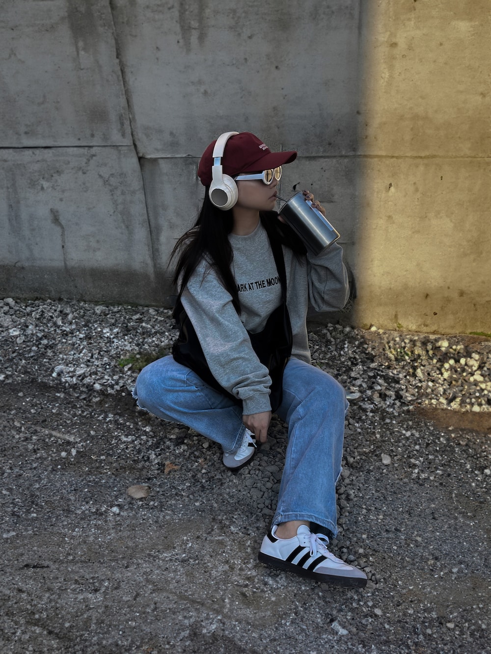 グレー系のスウェット、ブルー系のデニムパンツ、ホワイト系のスニーカーを着用したレディースの冬コーディネートの3枚目の写真