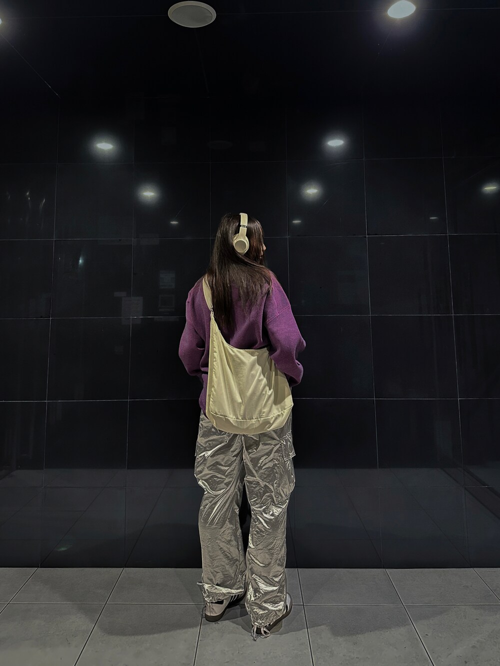 シルバー系のカーゴパンツ、パープル系のニット/セーター、ホワイト系のスニーカーを着用したレディースの秋コーディネートの2枚目の写真