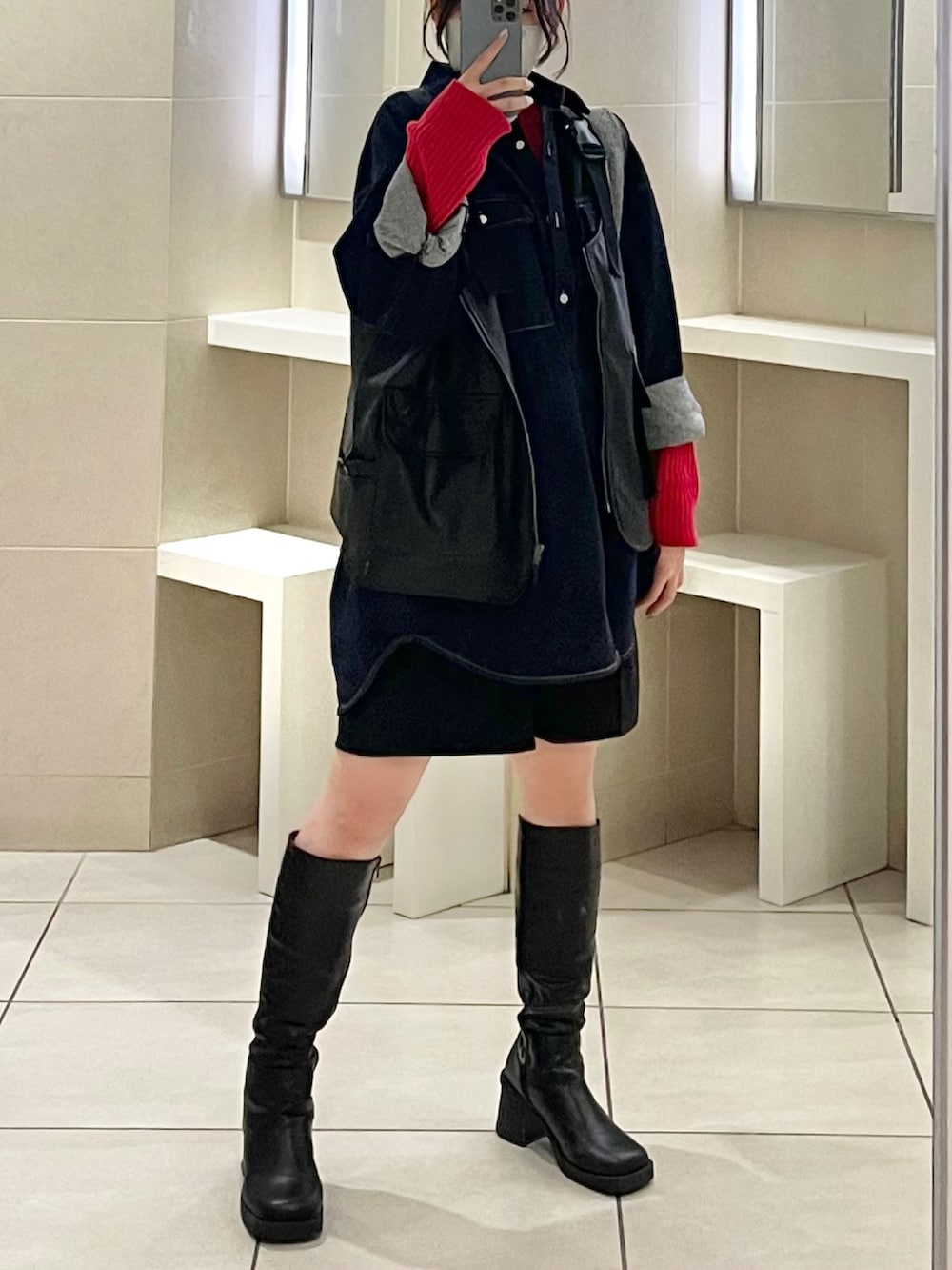 ブラック系のブーツ、シルバー系のトートバッグ、ブラック系のパンツを着用したレディースの冬コーディネートの3枚目の写真