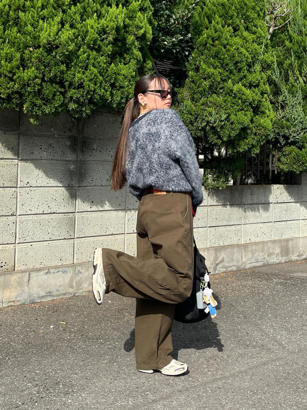 ブルー系のニット/セーター、グリーン系のデニムパンツ、ベージュ系のスニーカーを着用したレディースの秋コーディネートの3枚目の写真