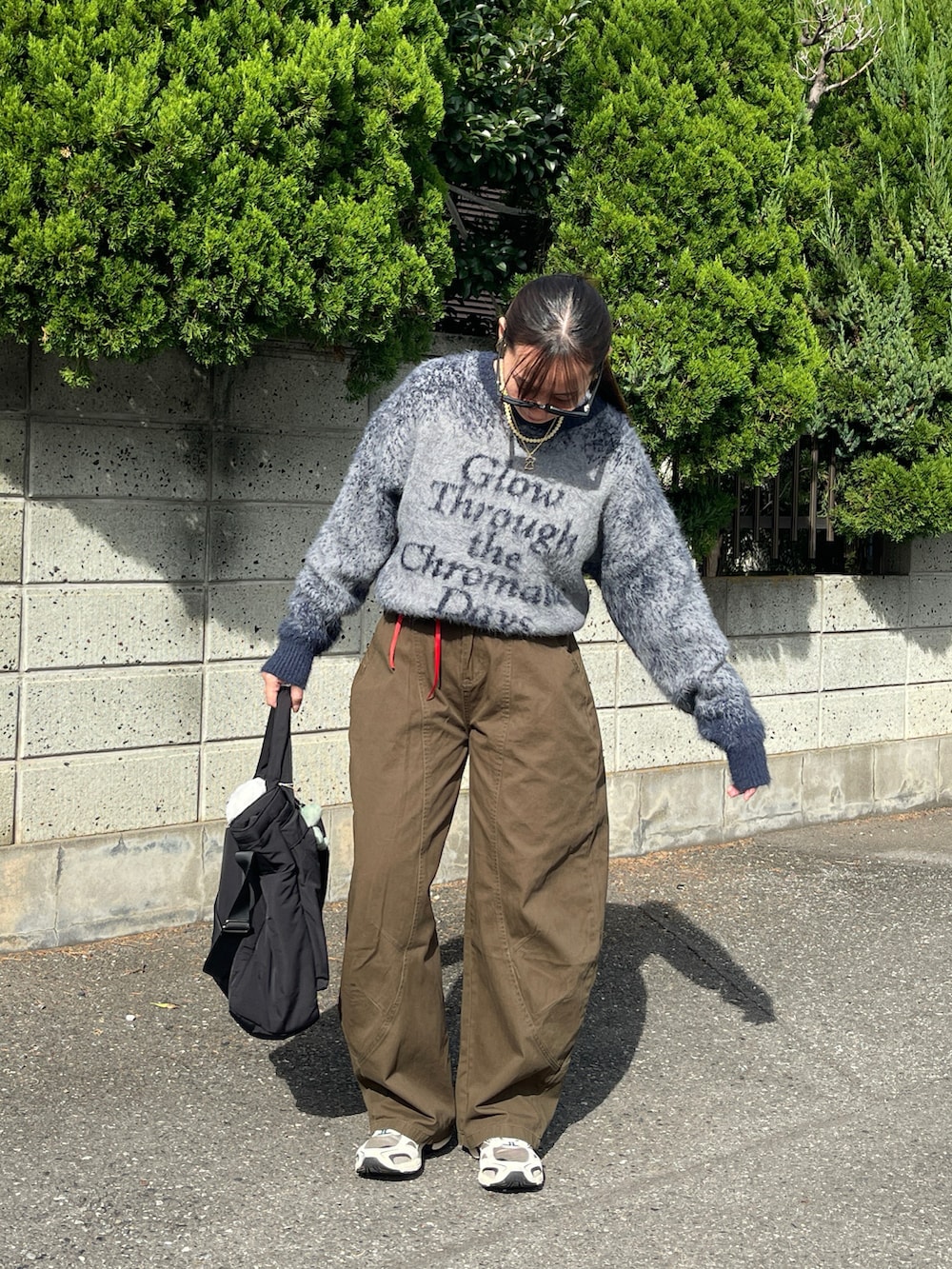 ブルー系のニット/セーター、グリーン系のデニムパンツ、ベージュ系のスニーカーを着用したレディースの秋コーディネートの4枚目の写真