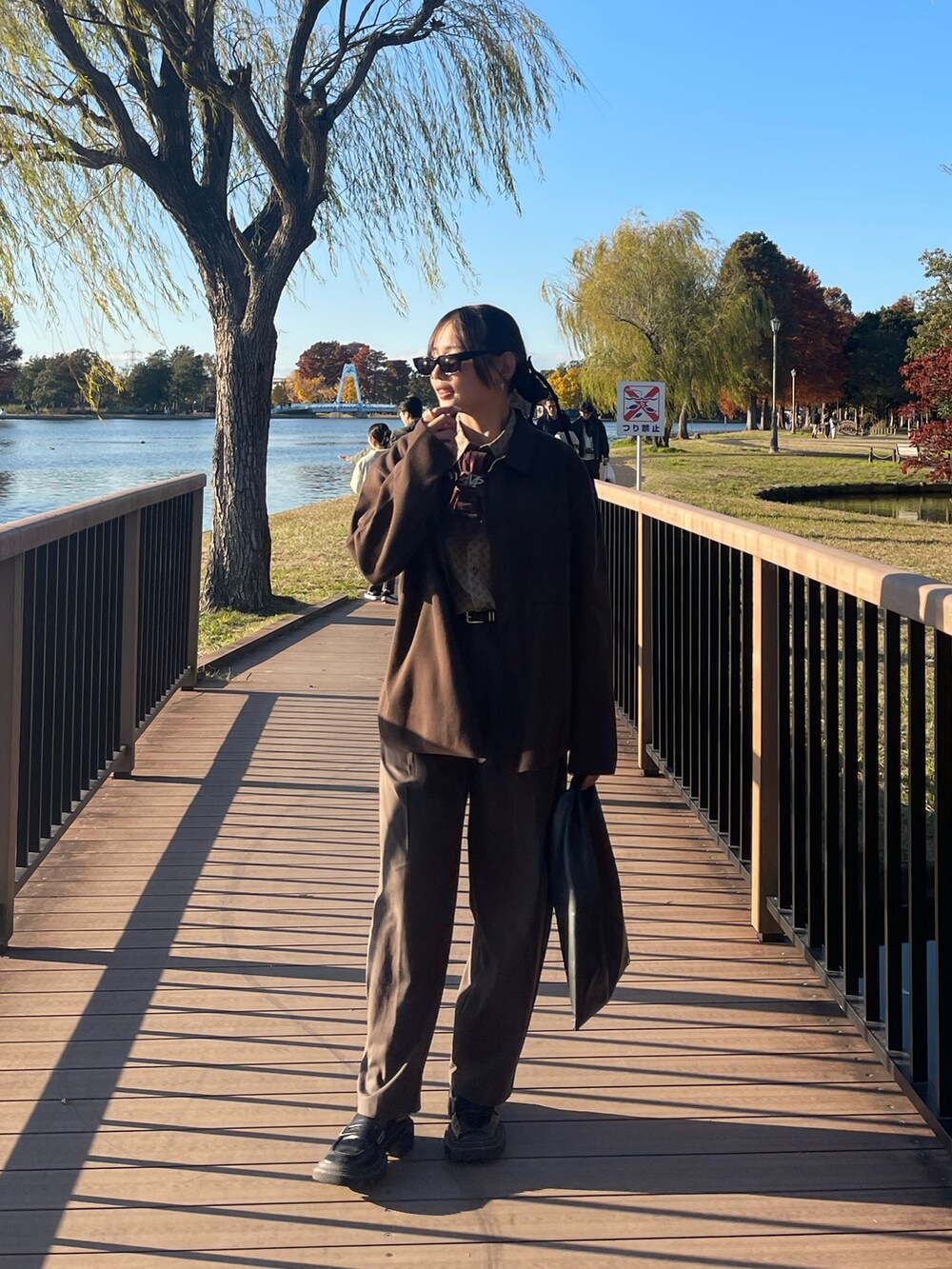 ブラウン系のカーディガン/ボレロ、ブラウン系のスラックス、ブラック系のローファーを着用したレディースの冬コーディネートの5枚目の写真