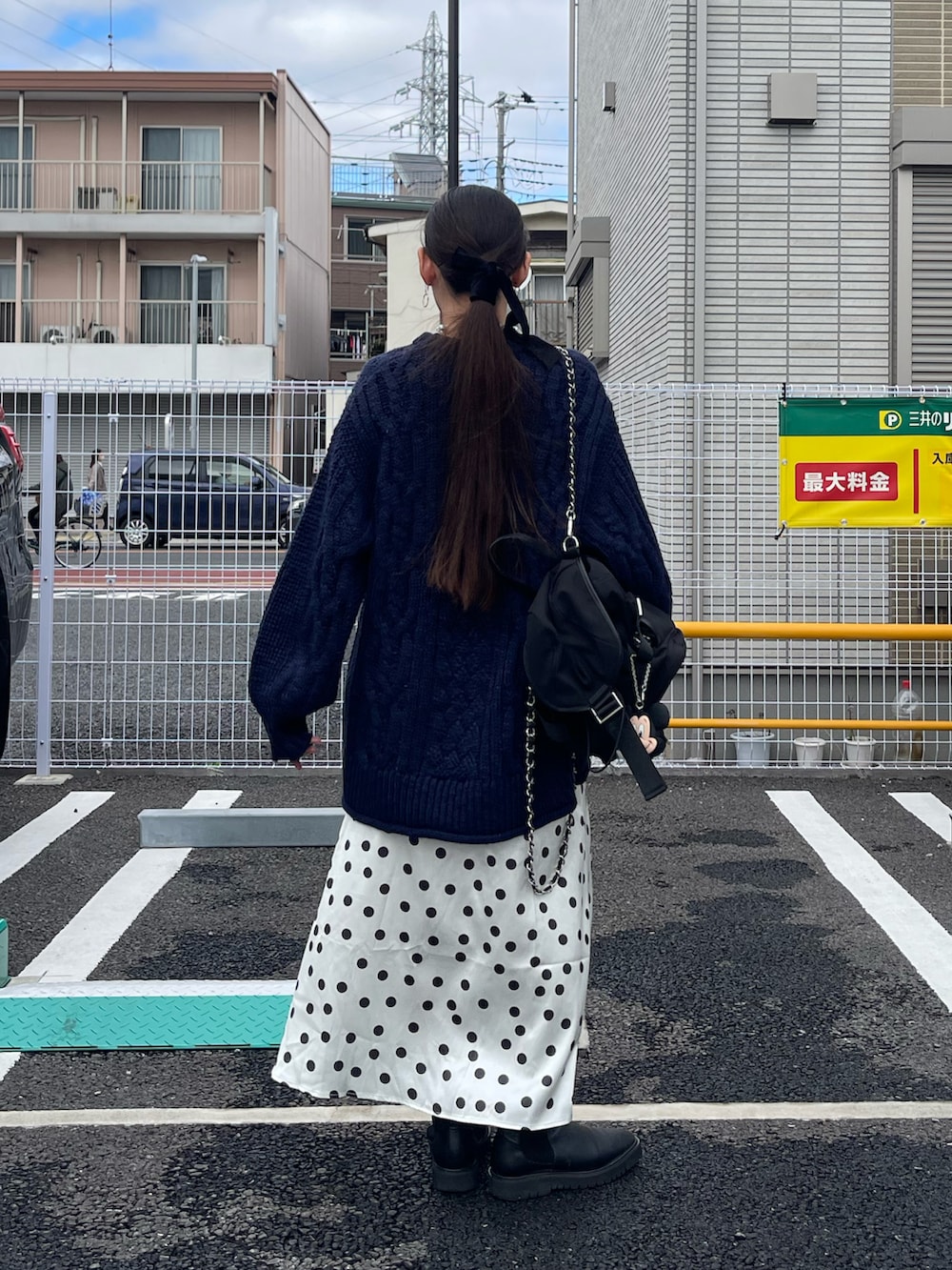 ホワイト系のスカート、ブラック系のバックパック/リュック、ブルー系のニット/セーターを着用したレディースの冬コーディネートの3枚目の写真