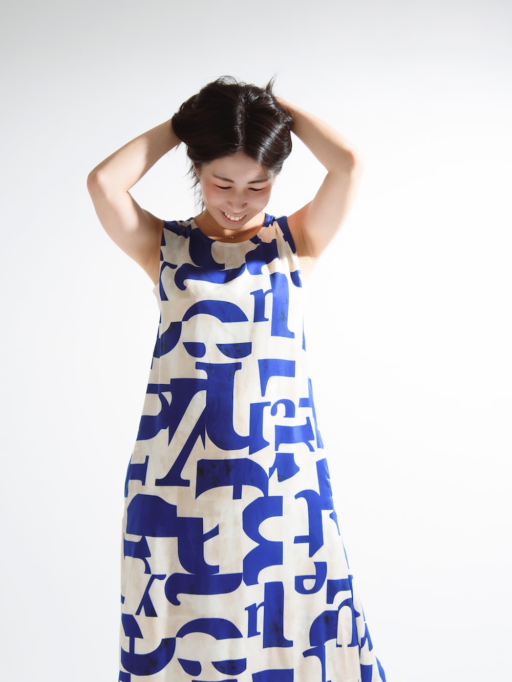 ブルー系のワンピース、ブラウン系のサンダルを着用したレディースの夏コーディネートの2枚目の写真