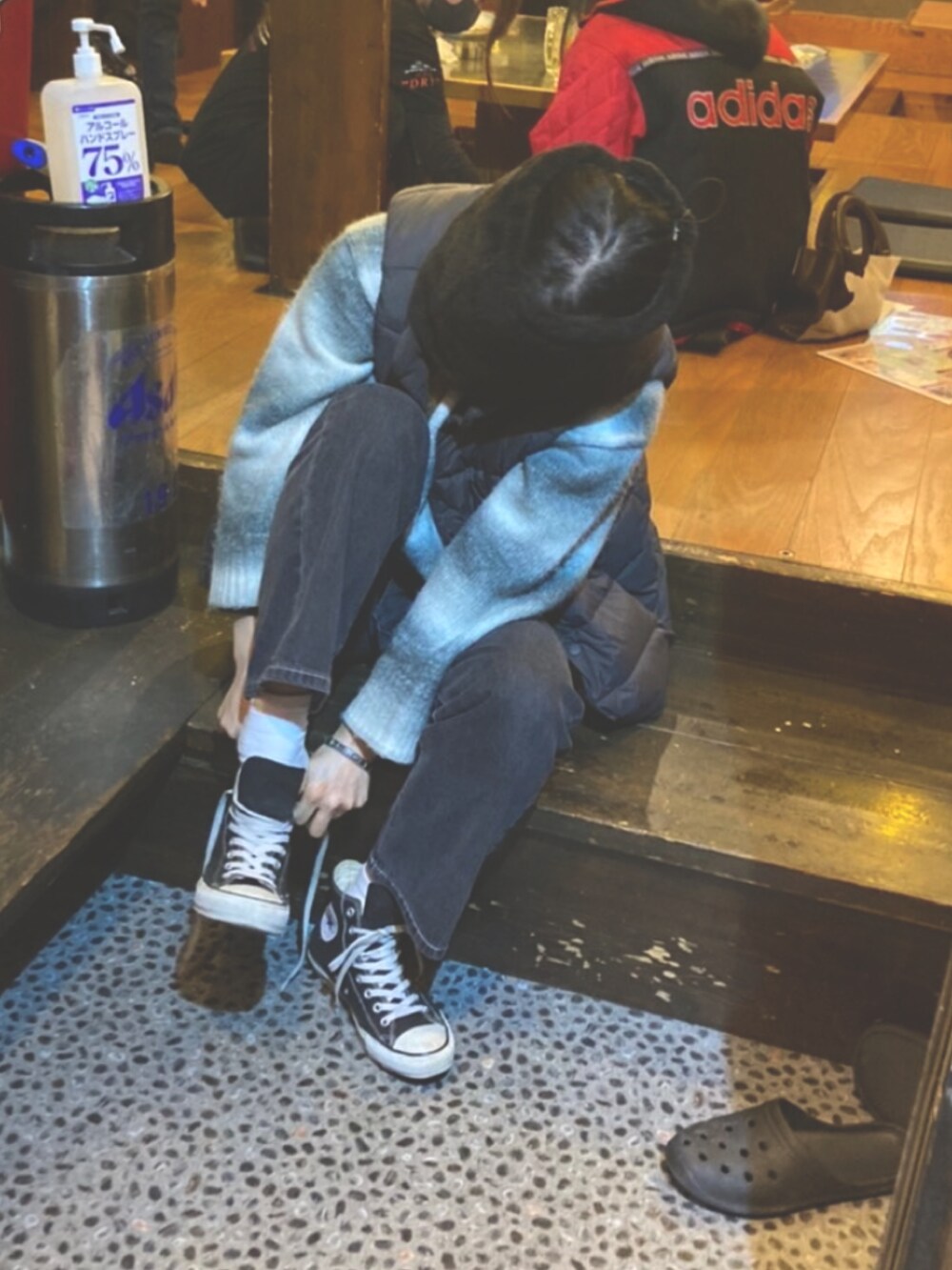 ブルー系のデニムパンツ、グレー系のニット/セーター、ブラック系のダウンベストを着用したレディースの冬コーディネートの2枚目の写真