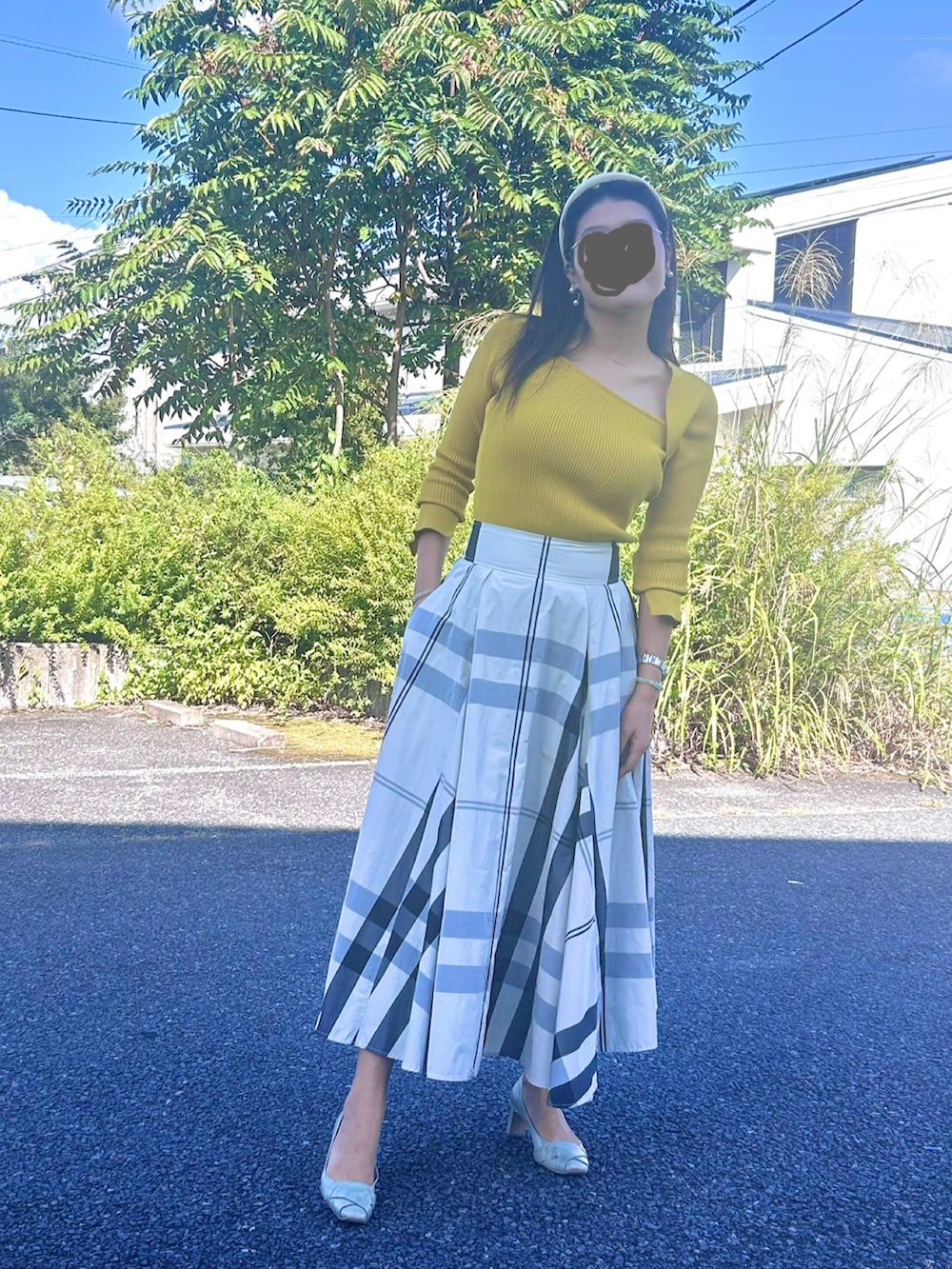 イエロー系のニット/セーター、その他のスカートを着用したレディースの秋コーディネートの2枚目の写真