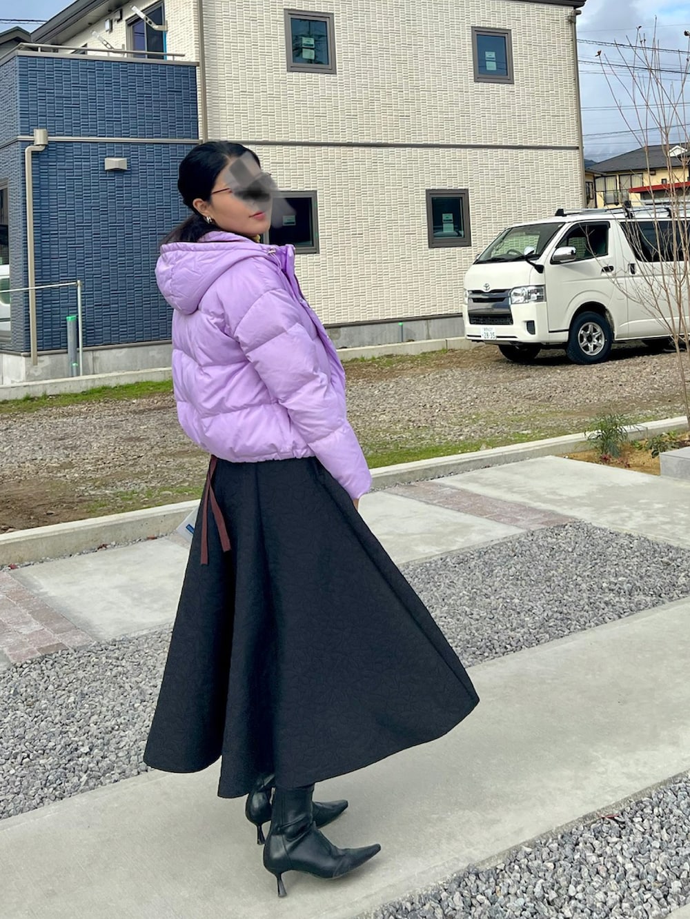 ブラウン系のTシャツ/カットソー、ブラック系のスカート、イエロー系のニット/セーターを着用したレディースの冬コーディネートの2枚目の写真