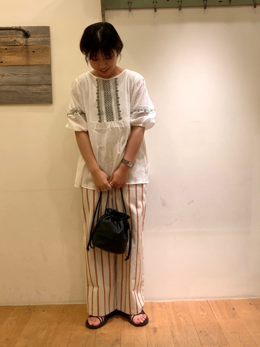 ブラック系のハンドバッグ、ホワイト系のシャツ/ブラウス、オレンジ系のその他パンツを着用したレディースの夏コーディネートの2枚目の写真