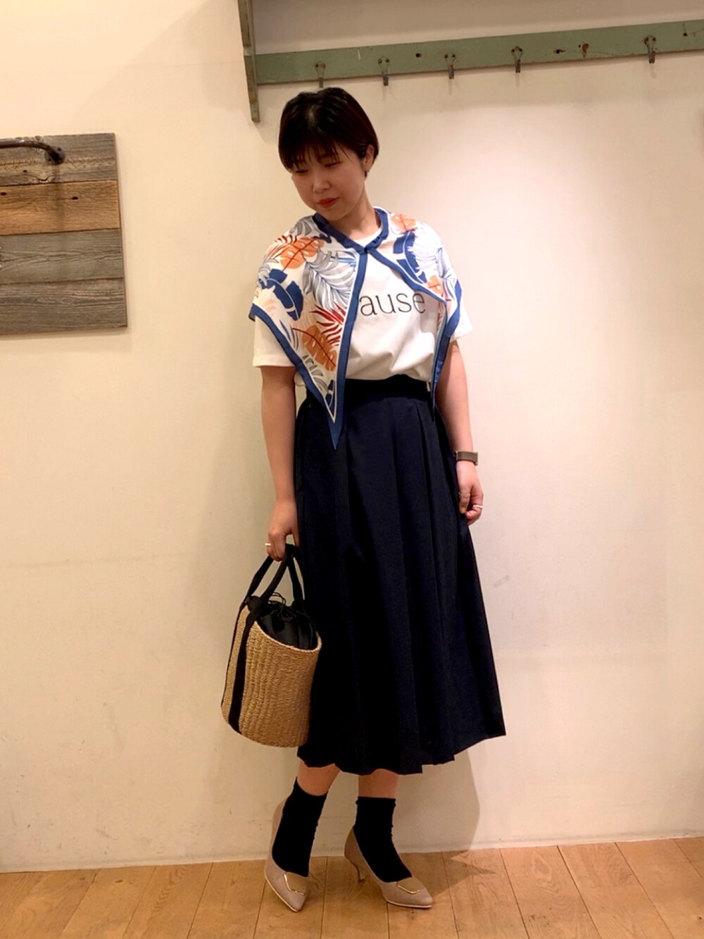 ブルー系のスカート、ベージュ系のパンプス、ホワイト系のTシャツ/カットソーを着用したレディースの春コーディネートの2枚目の写真