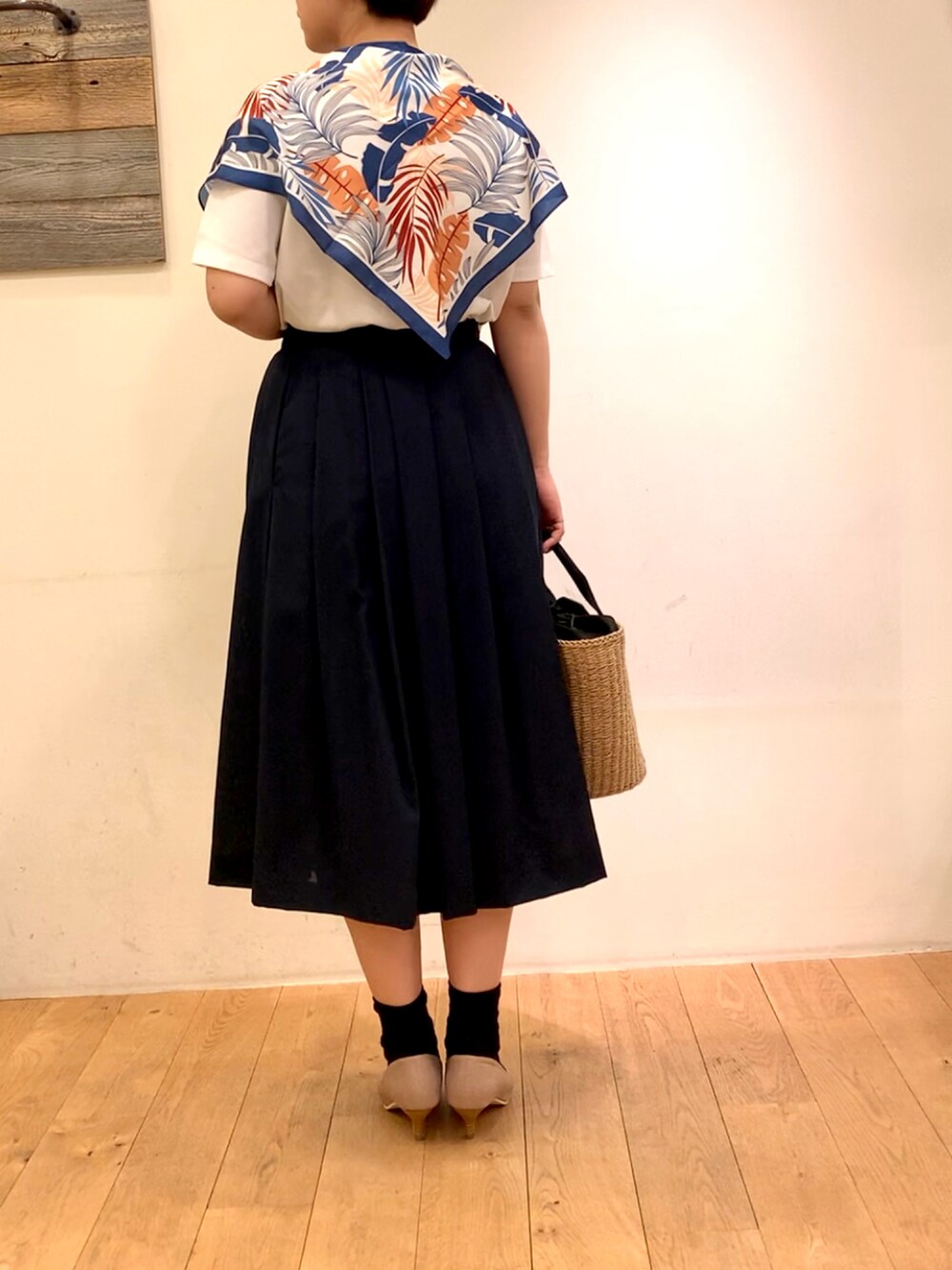 ブルー系のスカート、ベージュ系のパンプス、ホワイト系のTシャツ/カットソーを着用したレディースの春コーディネートの3枚目の写真