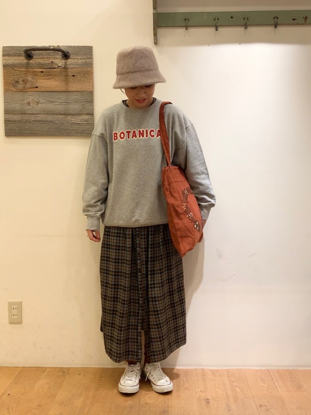 グレー系のTシャツ/カットソー、オレンジ系のトートバッグ、ブラウン系のワンピースを着用したレディースの秋コーディネートの2枚目の写真