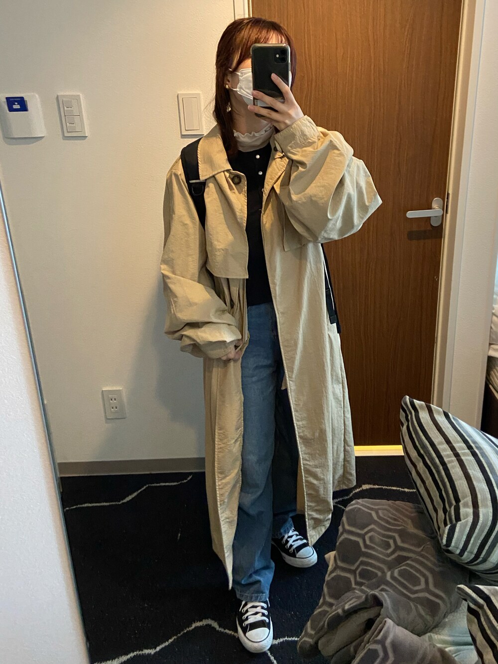 ブルー系のデニムパンツ、ブラック系のカーディガン/ボレロ、ホワイト系のトップスを着用したレディースの秋コーディネートの2枚目の写真