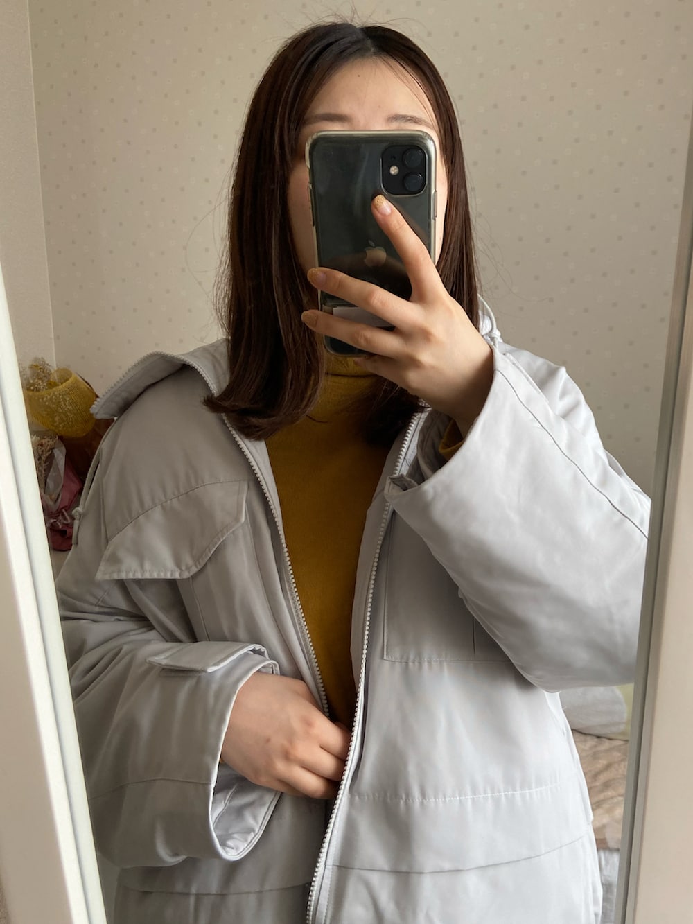 ホワイト系のダウンジャケット/コート、イエロー系のニット/セーター、ブラック系のその他パンツを着用したレディースの冬コーディネートの2枚目の写真