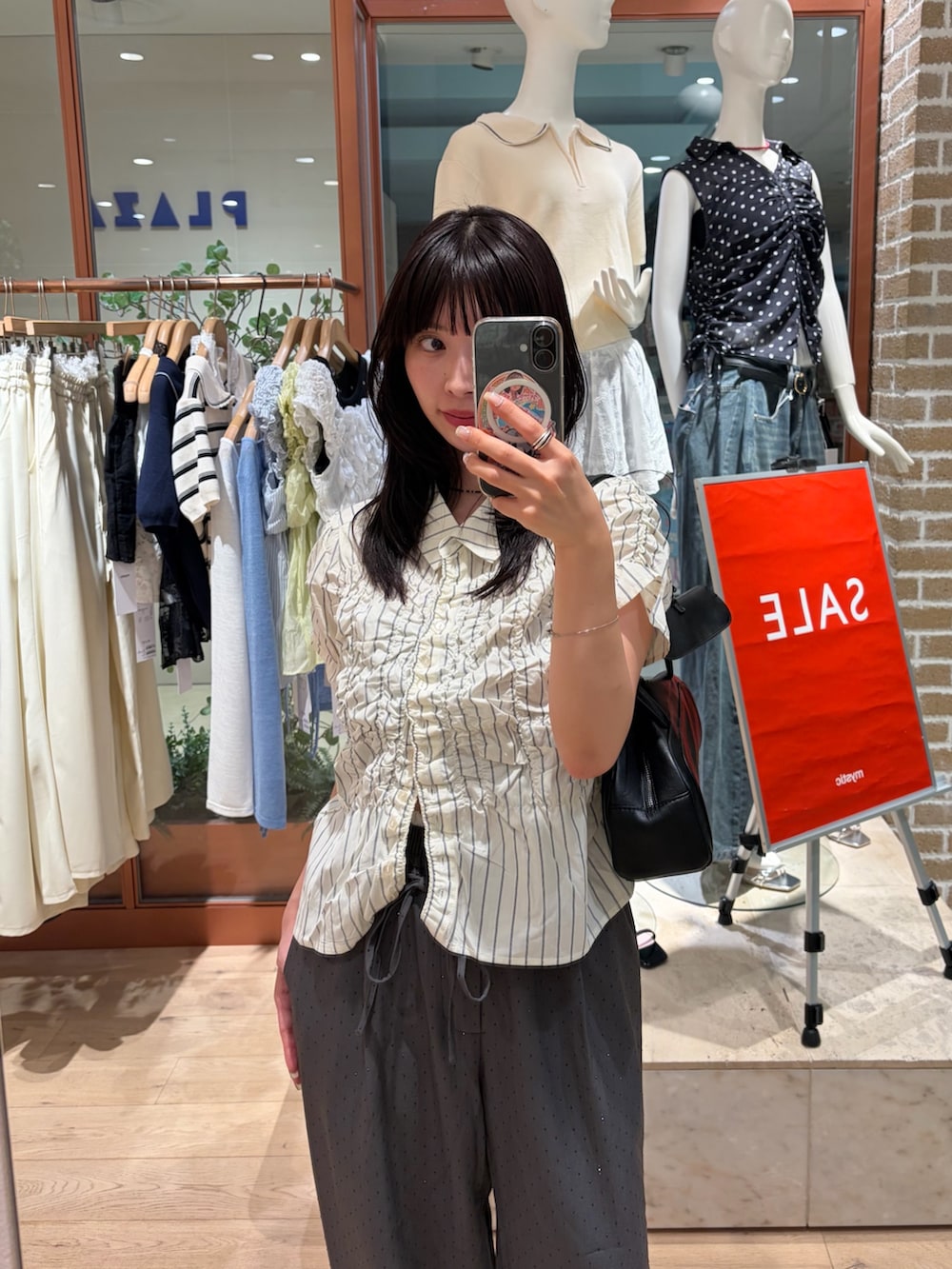 ホワイト系のシャツ/ブラウス、グレー系のスラックスを着用したレディースの夏コーディネートの3枚目の写真