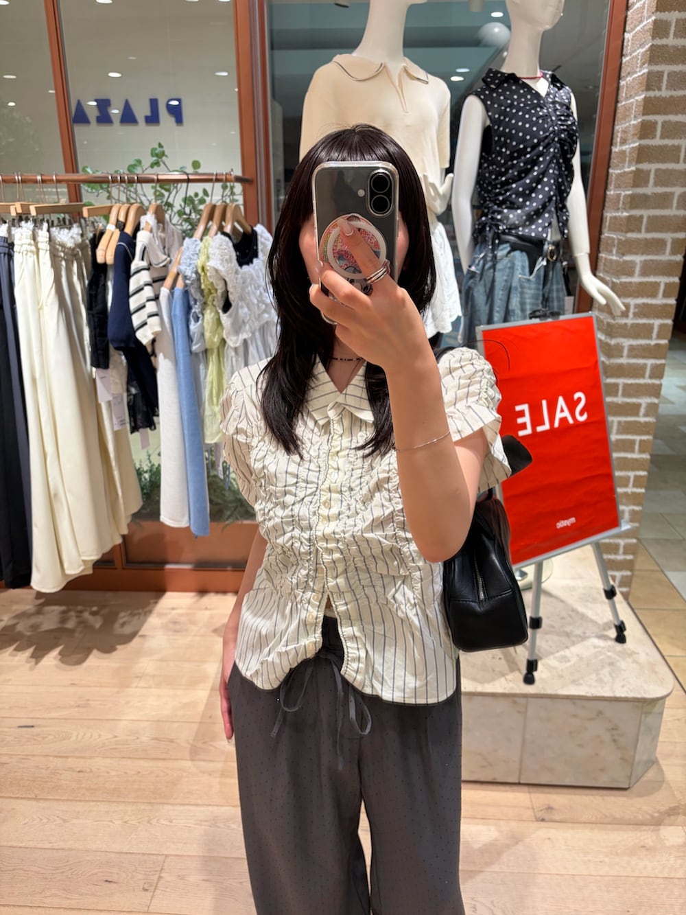 ホワイト系のシャツ/ブラウス、グレー系のスラックスを着用したレディースの夏コーディネートの2枚目の写真