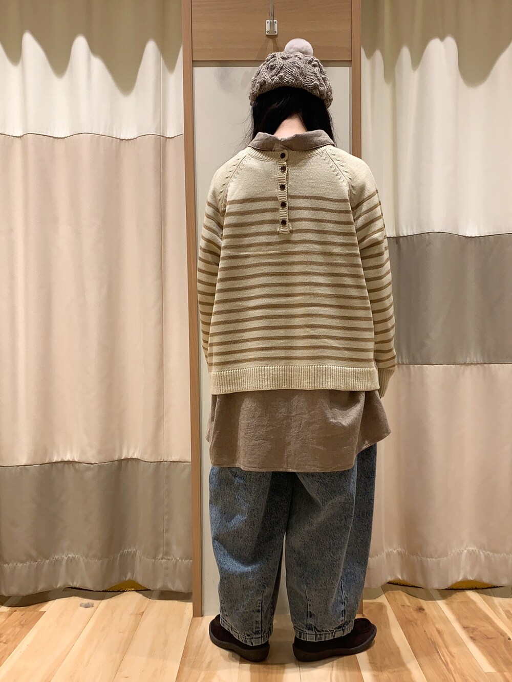 ベージュ系のニット/セーター、ブラウン系のチュニック、ブルー系のデニムパンツを着用したレディースの冬コーディネートの5枚目の写真
